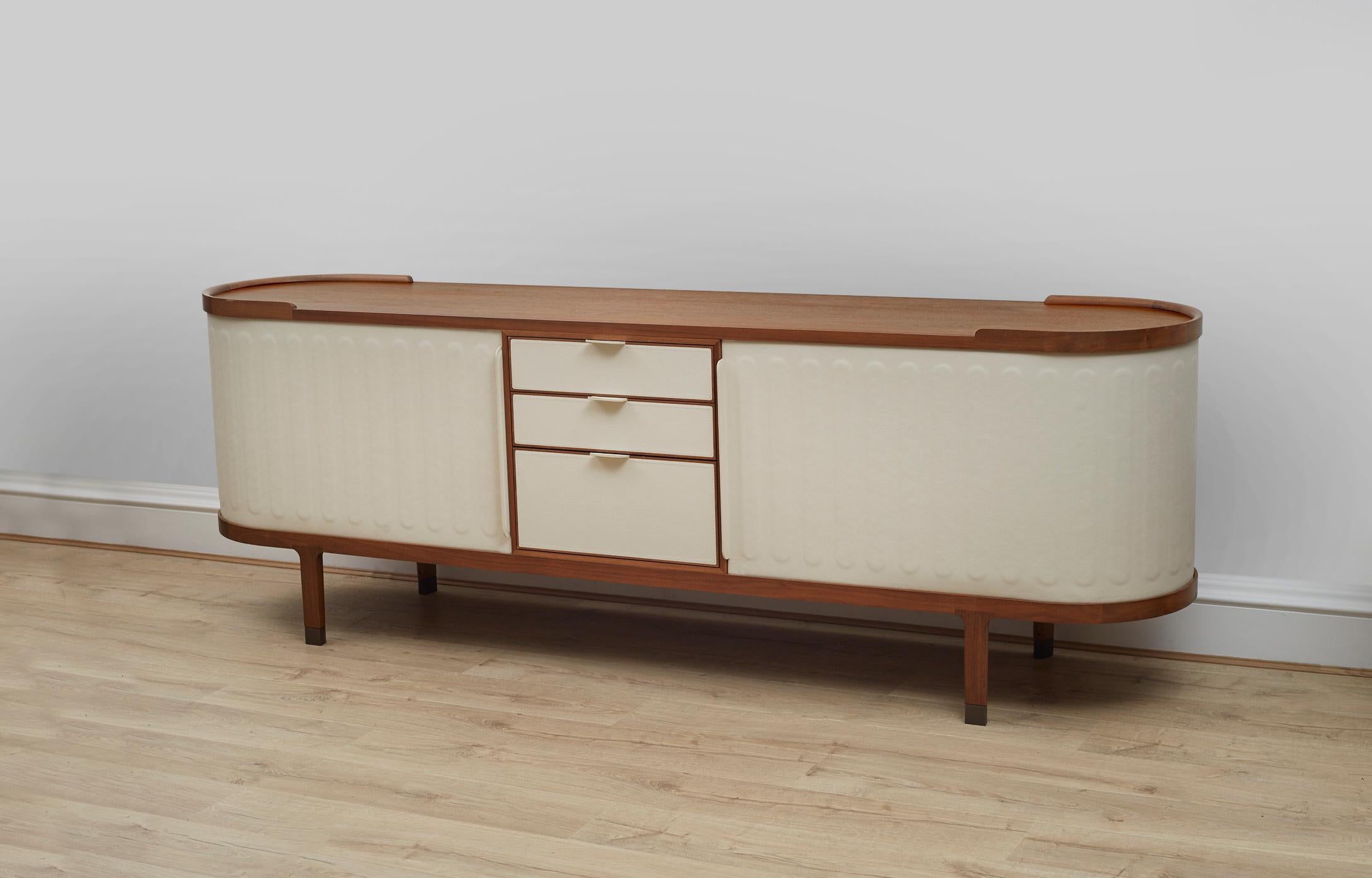 A Superb 'Dia' cabinet /sideboard designed by Chi Wing Lo for Giorgetti with sliding Cream coloured leather doors and a walnut canaletto wood frame, produced in 2012. 

It is composed of one chest of drawers, wood shelves and two adjustable height