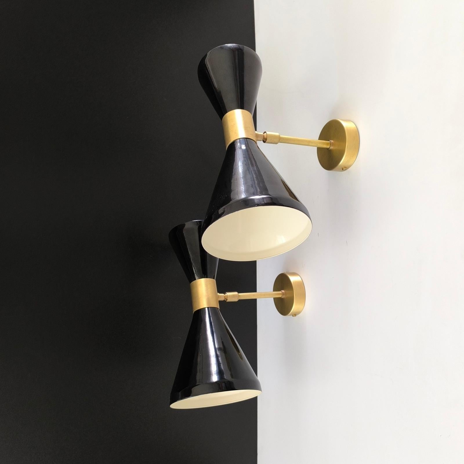 Paire d'appliques Diabolo réglables italiennes, dans le style de Stilnovo.
Laiton patiné et abat-jour laqué noir, chacun avec deux lumières.
Hauteur 26 cm.
Prises E12 ou E14 sur demande.
Des finitions optionnelles sont disponibles moyennant un