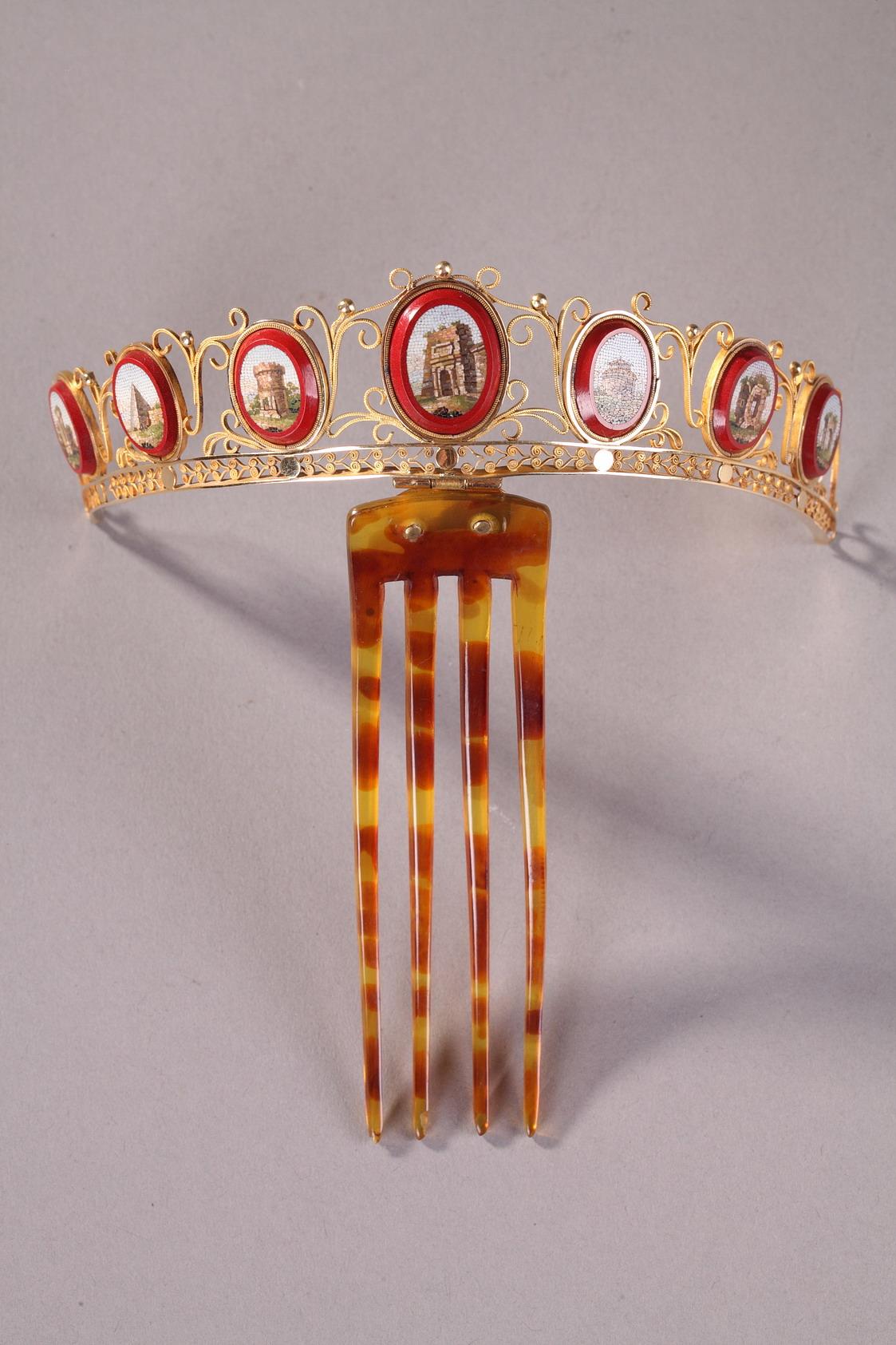 Diadem comb in gold featuring seven oval, micromosaic medallions. The removable comb of the diadem is composed of four, blonde tortoiseshell teeth. The curved diadem features micromosaic medallions set on a coral red background. Each medallion