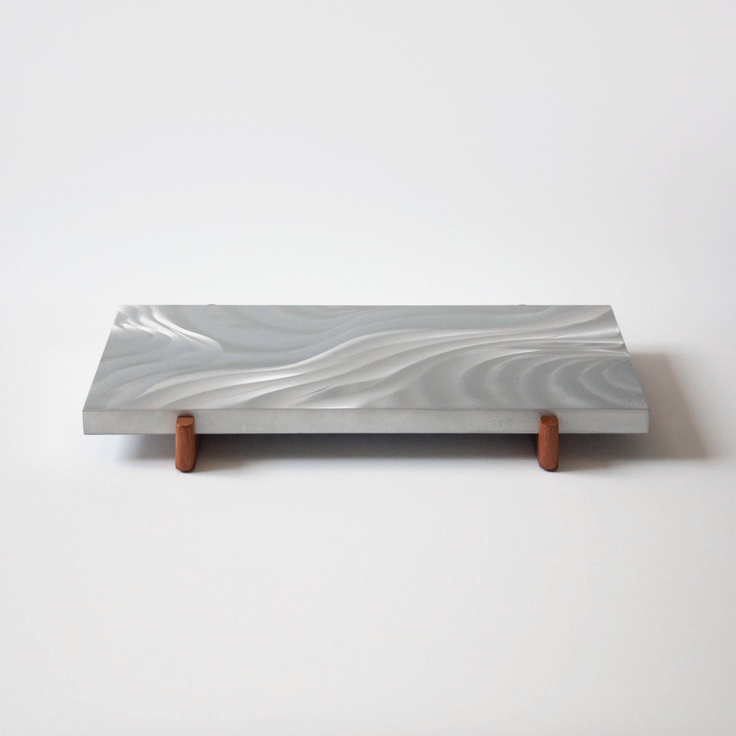 The Meltemi Tray – an offspring of the Meltemi cabinet – features the same experimental surface treatment. Like the Aegean winds, the tools and the metal surface dictate the final sculptural finish of this rectangular tray.

! Please note that the