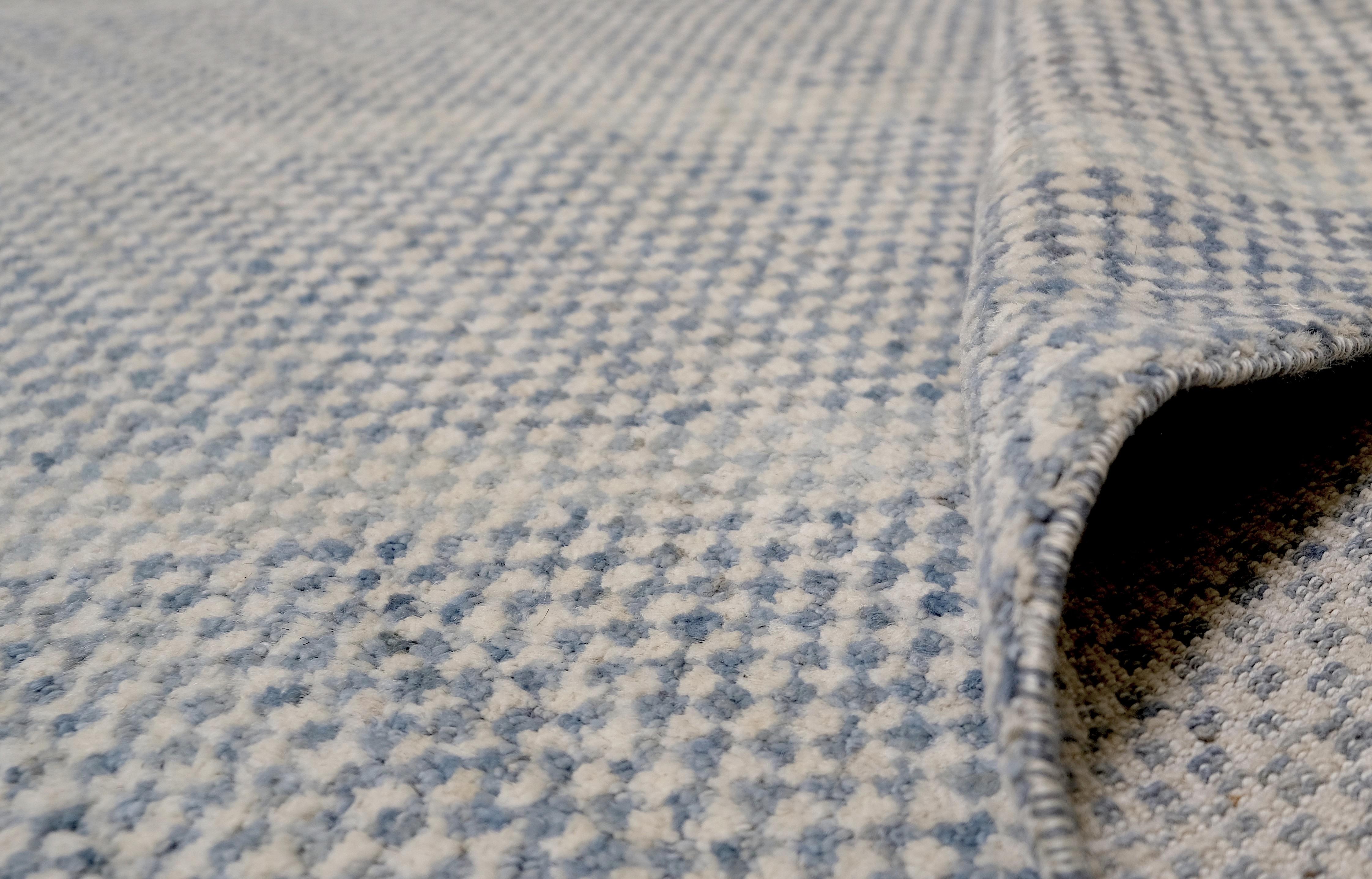 Introduce a touch of modern elegance to your home with this exquisite hand-knotted wool rug. Featuring a subtle blue and ivory diagonal stripe design, this rug combines simplicity with sophistication, creating a serene and versatile aesthetic that