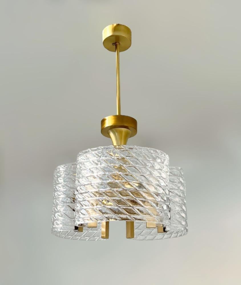 Lustre italien avec abat-jour en verre clair de Murano soufflé à la main en forme de diamant stylisé et effet texturé, monté sur une monture en laiton massif en finition laiton satiné, conçu par Fabio Bergomi pour Fabio LTD / Made in Italy 
6 lampes