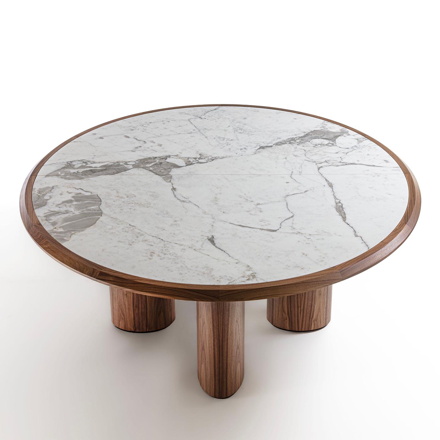 Geometric volumes made unique by the use of splendid natural materials distinguish this superb table of modern inspiration. Majestic addition to a dining room, it boasts a solid Canaletto walnut structure with four elliptic-cut legs and a circular