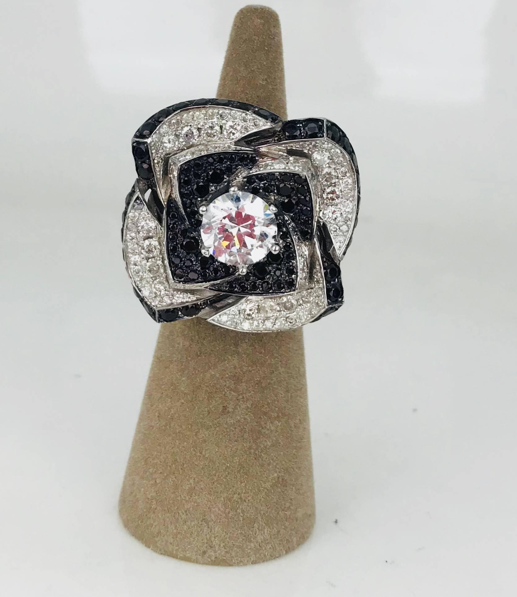 Diamond & black spinel flower ring with 7.75 carat diamonds and 5 carats spinel in a Modern style design.
A Hollywood- style ring with diamonds & black spinel set as a floral design in 14 karat white gold. 
The underneath layer of metal, under the