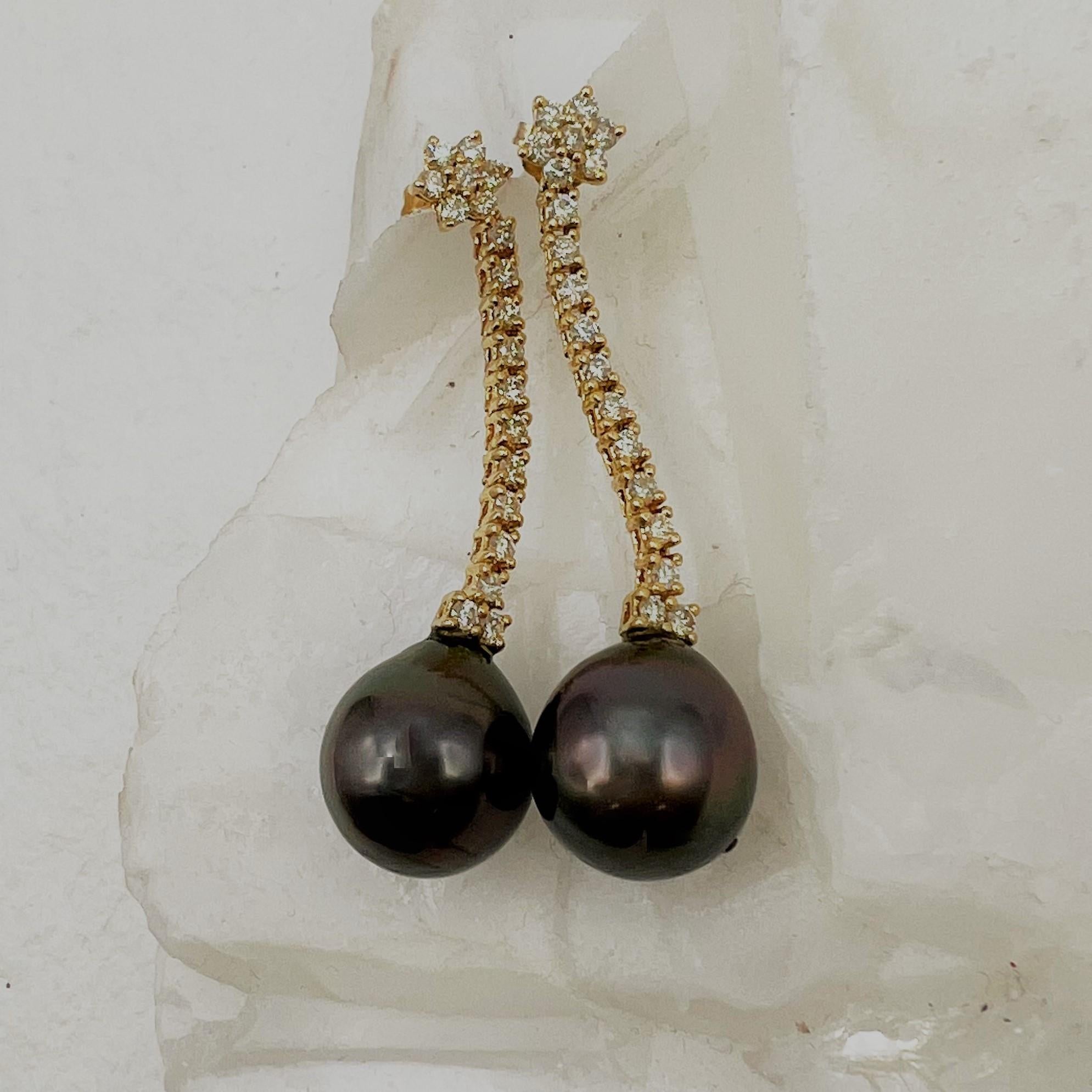 These diamond drop earring with the diamond flower shape posts have the iridescent Tahitian pearls in deep grey. The diamond weight of the 38 diamonds is 0.76 Carats Total weight. The pearls measure 14 mm and are beautifully matched.