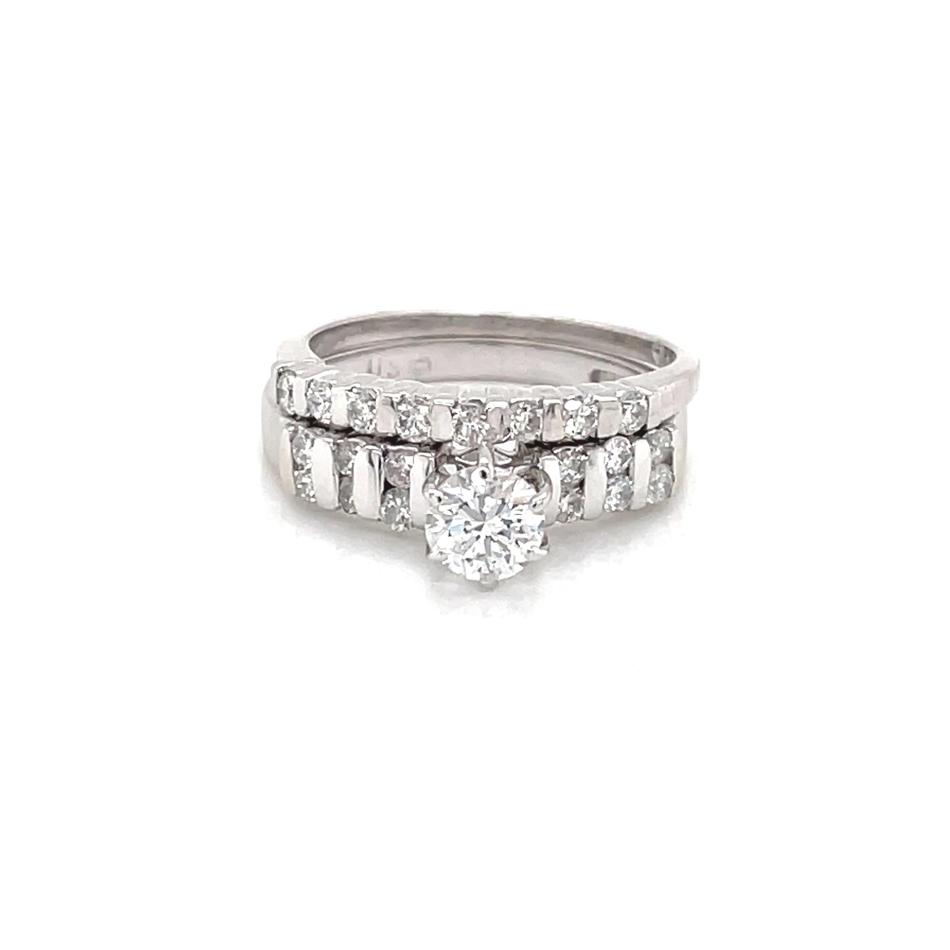 A sparkling .45 carat round faceted H/SI center diamond is flanked by a total of twelve round faceted .03  carat diamond accents that are twin set, vertically,  in 14 karat white gold for maximum impact. The accompanying band presents eight round