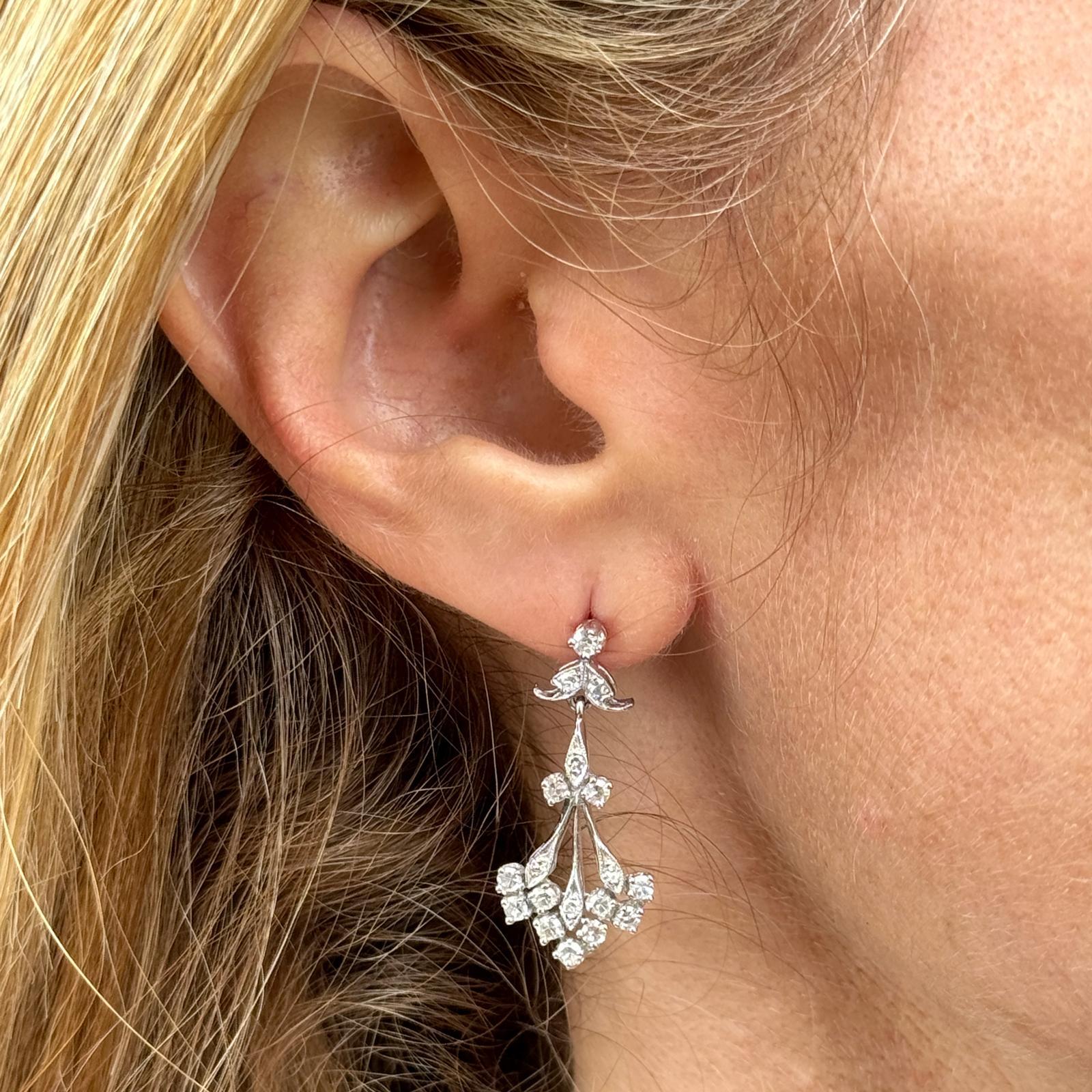 Diamond dangle vintage earrings fashioned in 14 karat white gold. The earrings feature 36 single cut diamonds weighing approximately 1.00 carat total weight and graded H-I color and SI clarity. The earrings measure 1.25 inches in length. Weight: 4.1