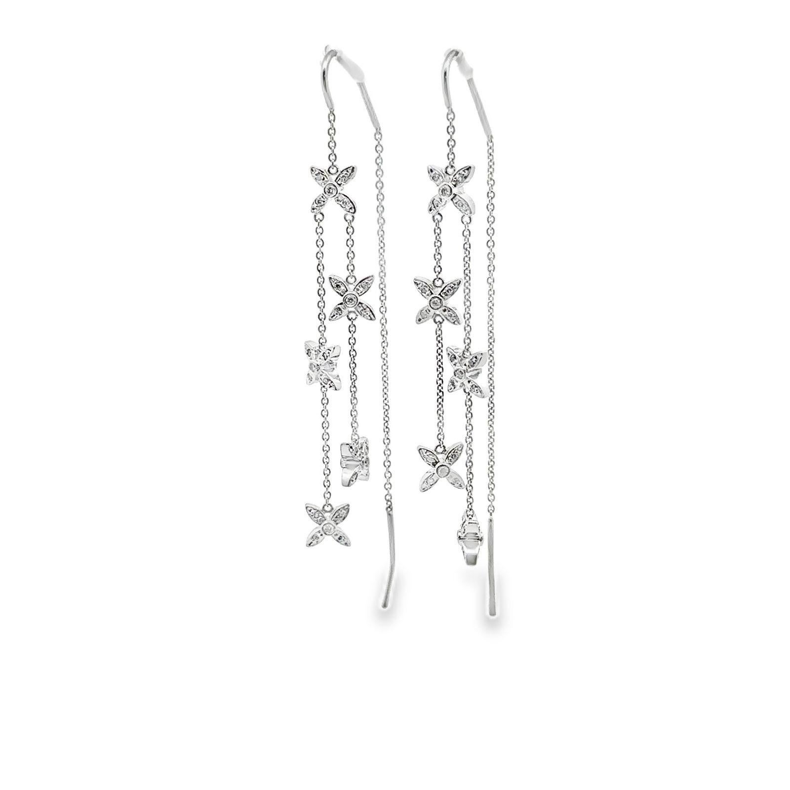 Gli orecchini Diamond Threader Star hanno un design elegante e moderno realizzato in oro bianco 14 carati. Questi eleganti orecchini a lobo presentano una delicata catena che attraversa l'orecchio, con charme a stella ornati di diamanti che creano