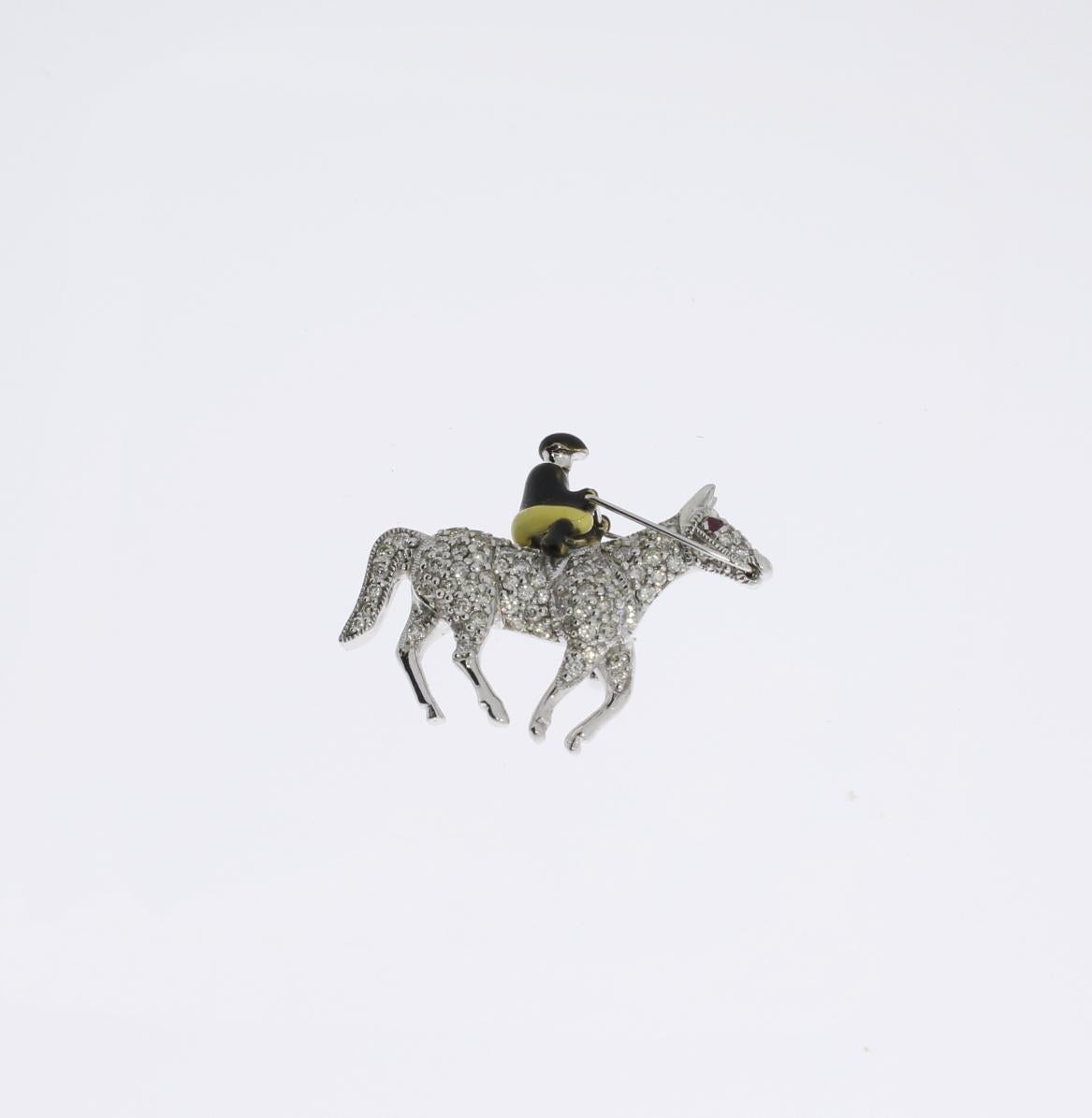 Europe, late 20th century. The horse set with 78 brilliant-cut diamonds weighing approximately 0,93 ct. and with a ruby of about 0,04 ct. The rider embellished with enamel. Made in 18K white gold. Total weight: ca. 11 g. 
Dimensions: 0.98 x 1.3 in (