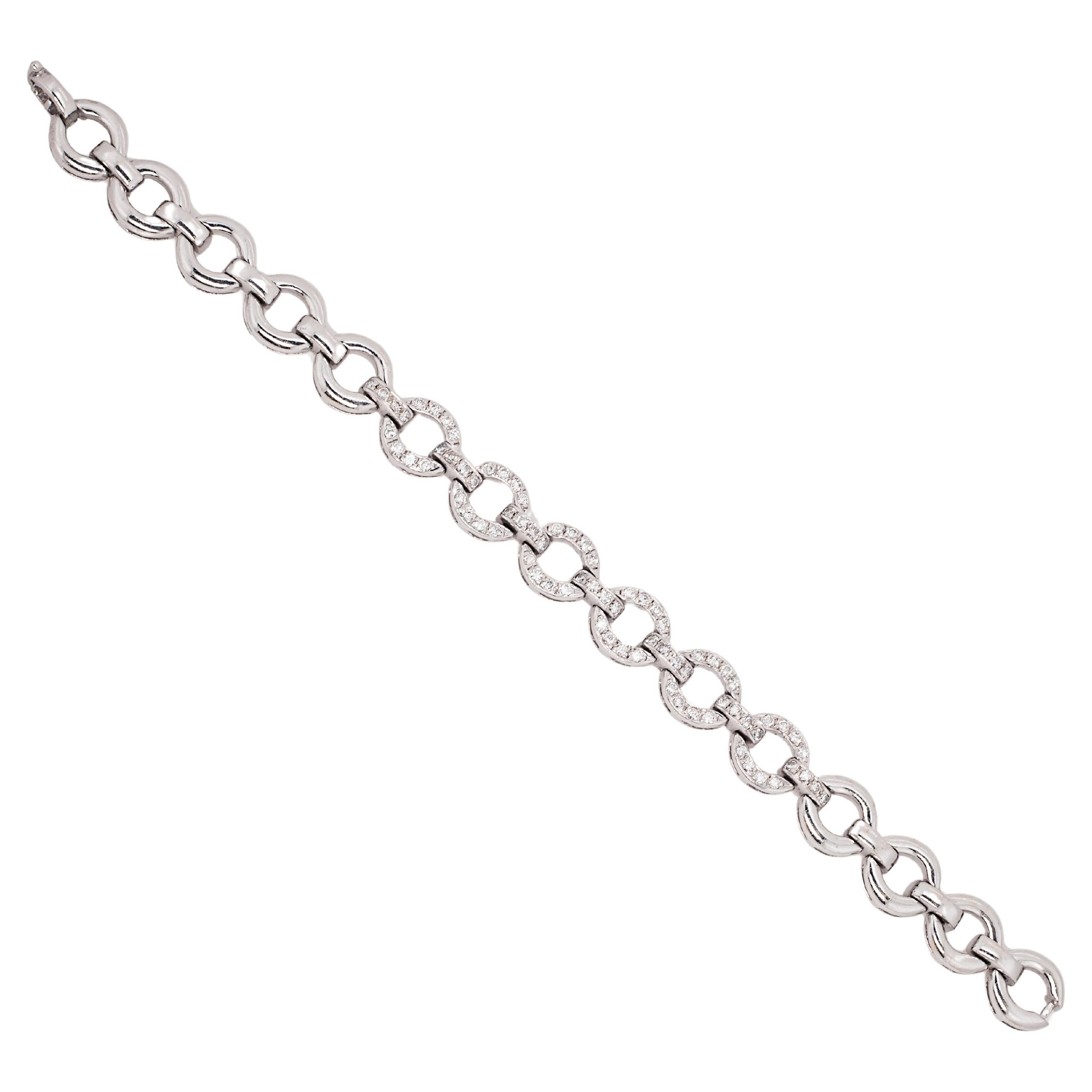 Exuding a special finesse through its expertly crafted details, this 18 carat white gold bracelet is designed as an articulated series of high-polish and diamond set oval shaped links, alternating with bar links. The central links are beautifully