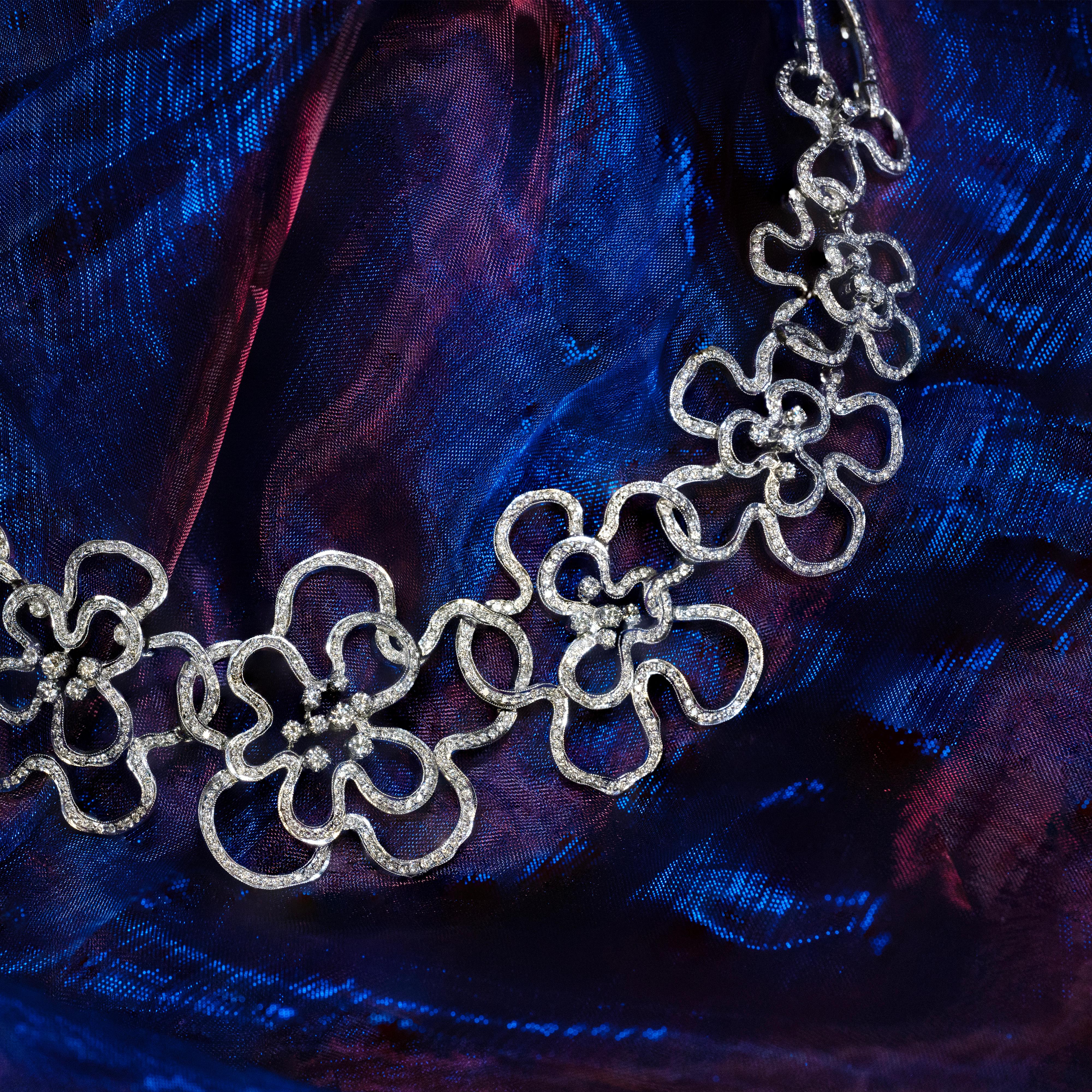 Diese spektakuläre Halskette zeichnet sich durch ein allmählich durchbrochenes Blumendesign aus, das aus 18 Karat Weißgold gefertigt ist. Für zusätzliche Eleganz ist die gesamte Oberfläche der Halskette mit hochwertigen runden Diamanten im