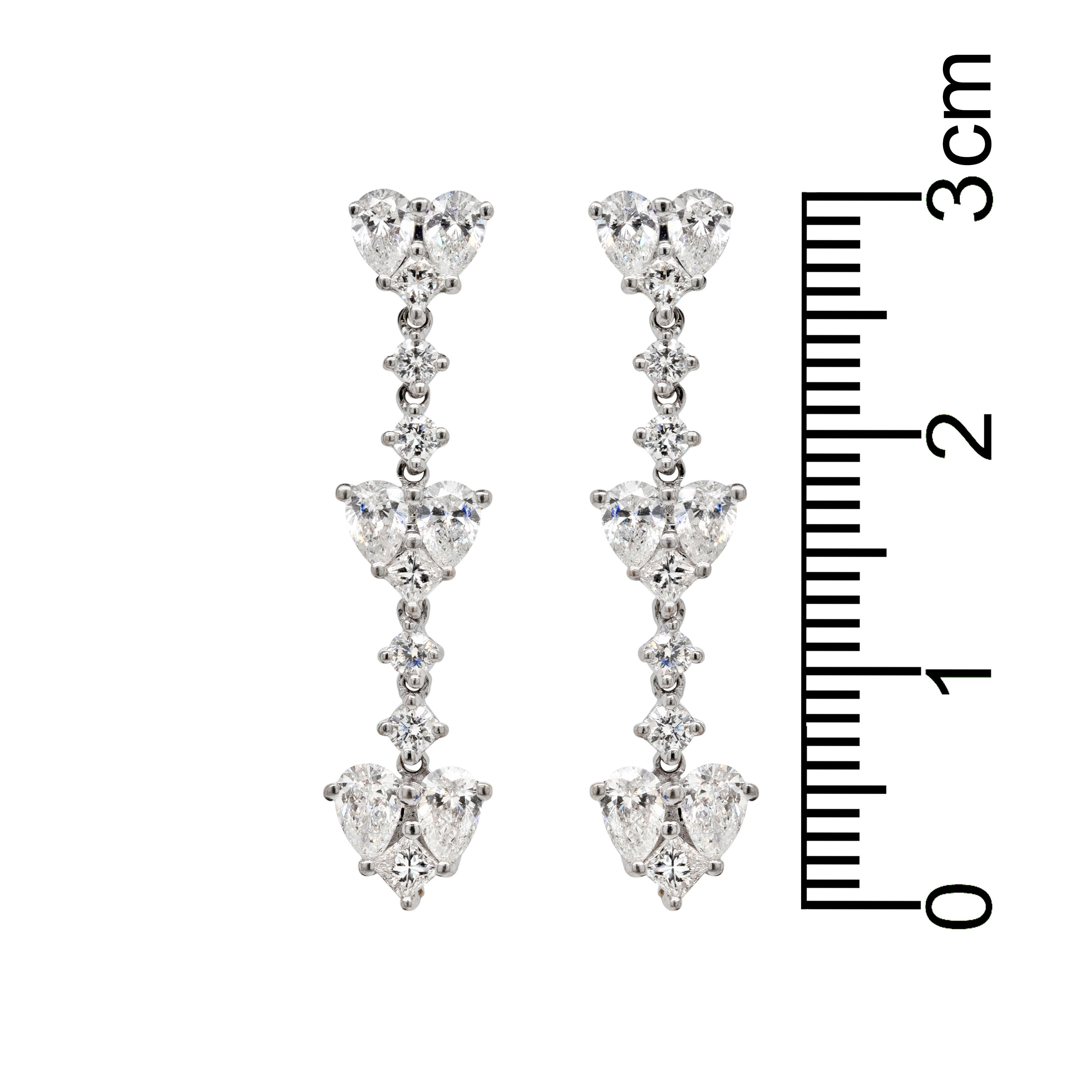 Exquisite heart drop earrings beautifully inlaid with a mix of pear shaped diamonds, princess cut diamonds and round brilliant cut diamonds, weighing approximately 1.40ct in total, all claw set in 18 carat white gold. These delicate pieces have a