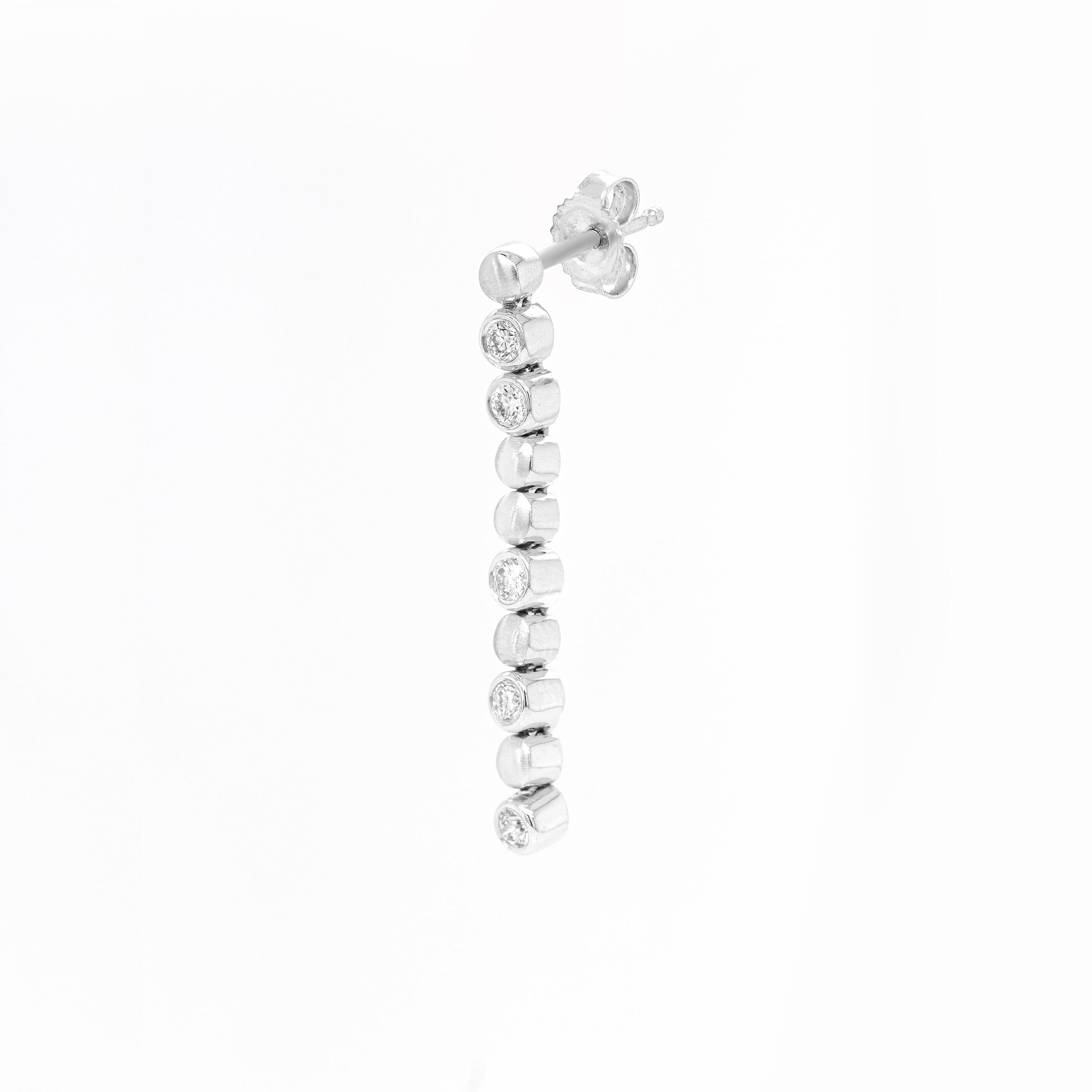 Beautiful and delicate, these linear drop earrings showcase 5 round brilliant cut diamonds, weighing approximately 0.60ct combined, all mounted in 18 carat white gold rub-over, open back settings. The sparkling diamonds alternate with five 18 carat