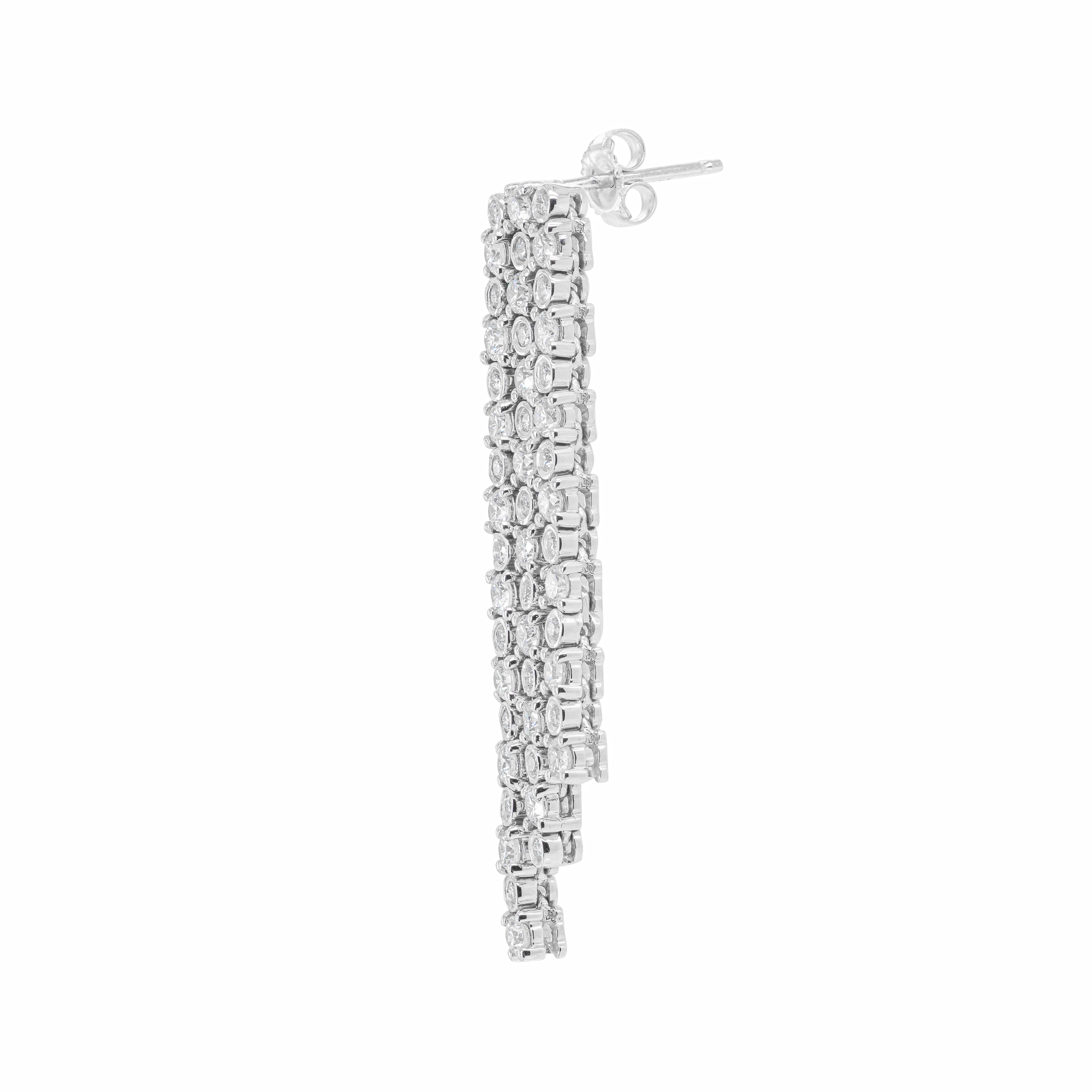 These exquisite drop earrings feature a fringe dangle design masterfully crafted from 18 carat white gold. Each earring is inlaid with 48 round brilliant cut diamonds mounted in alternating four claw and rub-over open back settings, weighing