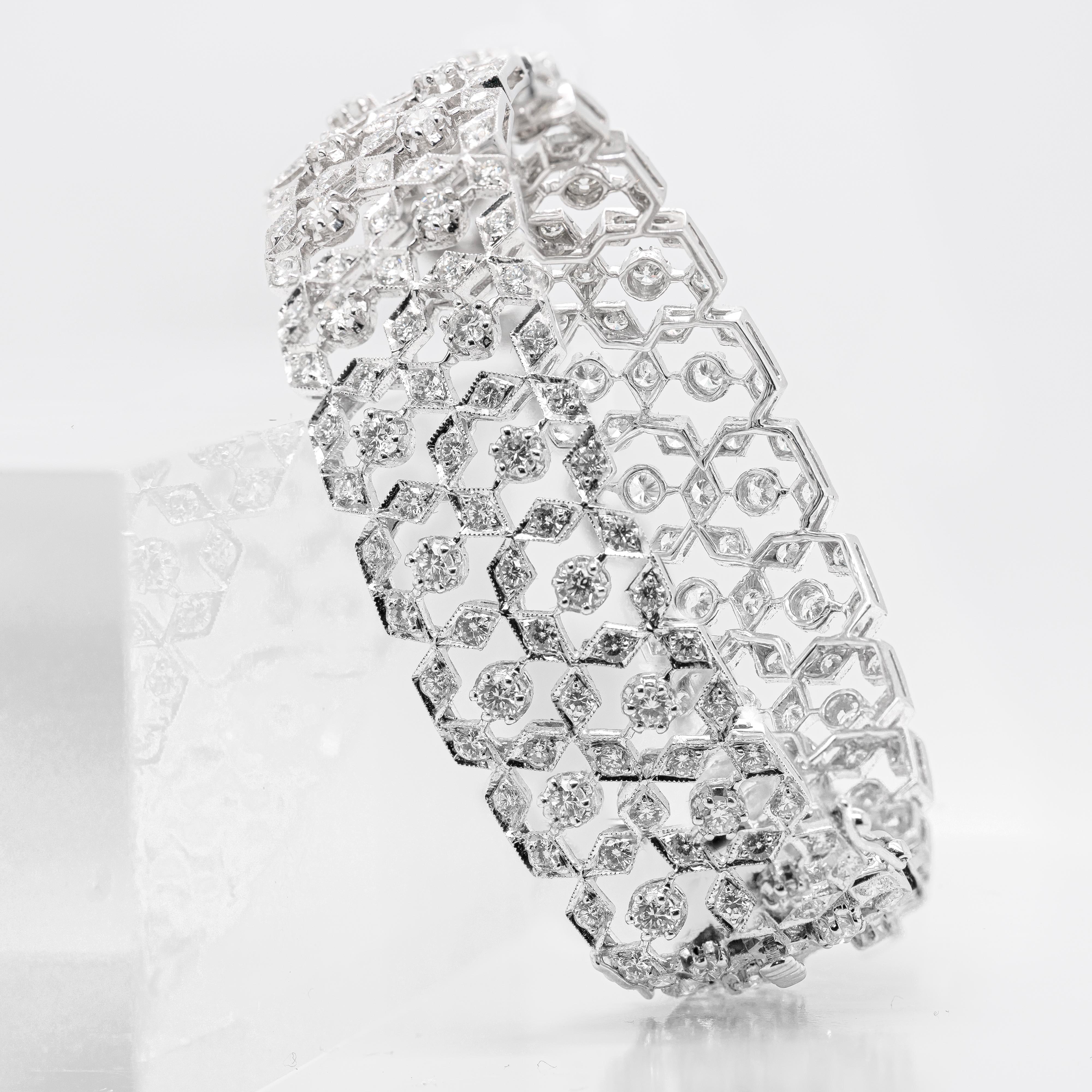 This 18 carat white gold bangle features an impressive open work design consisting of hexagonal shapes that are interlocking to create this beautiful and exquisite piece. The delicate hexagons are composed of six fine quality brilliant cut diamonds