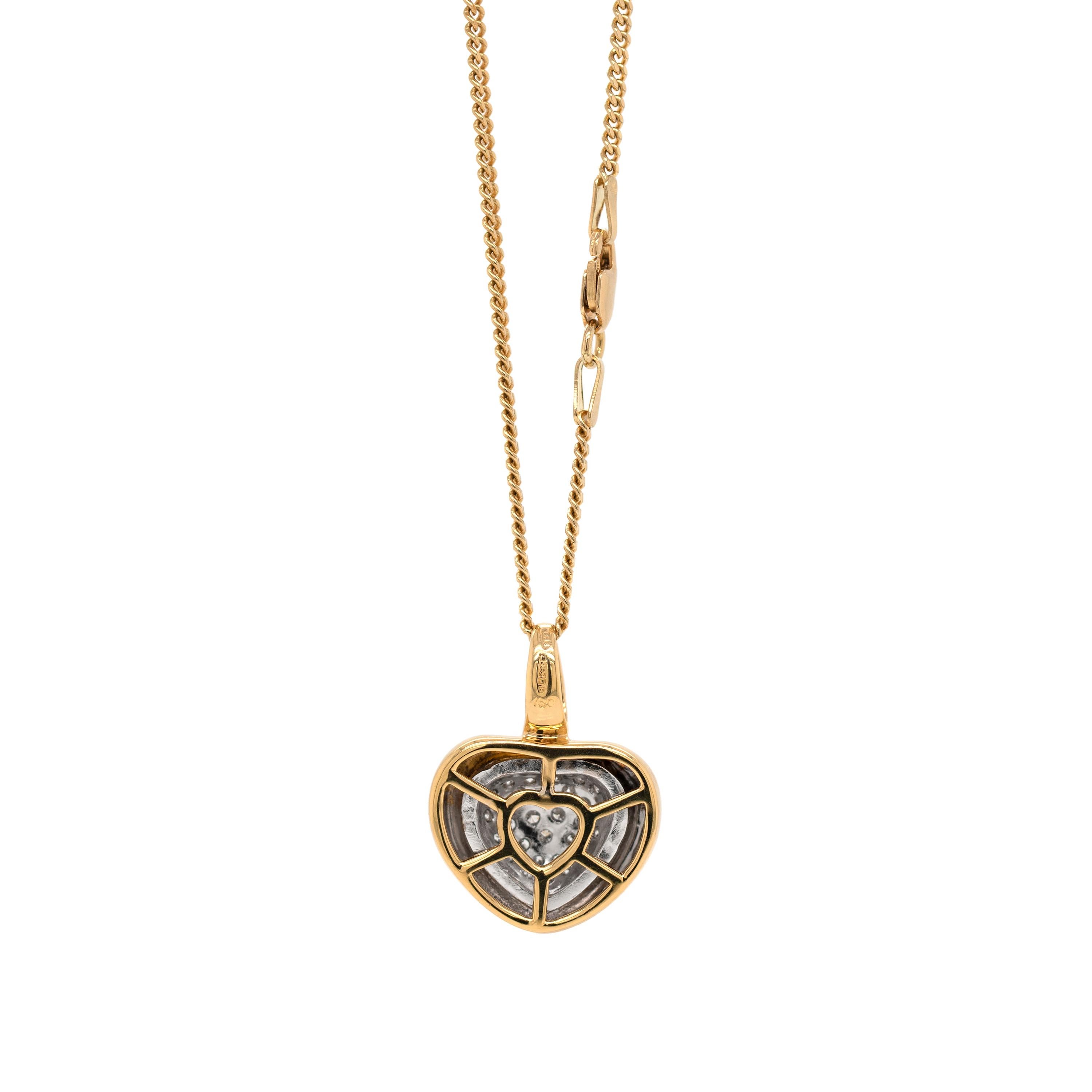 This beautiful 18 carat gold pendant features a white gold heart in the centre, pavé set with 29 fine round brilliant cut diamonds, weighing a total approximate weight of 0.60ct. A thick yellow gold border surrounds the centre heart completing the