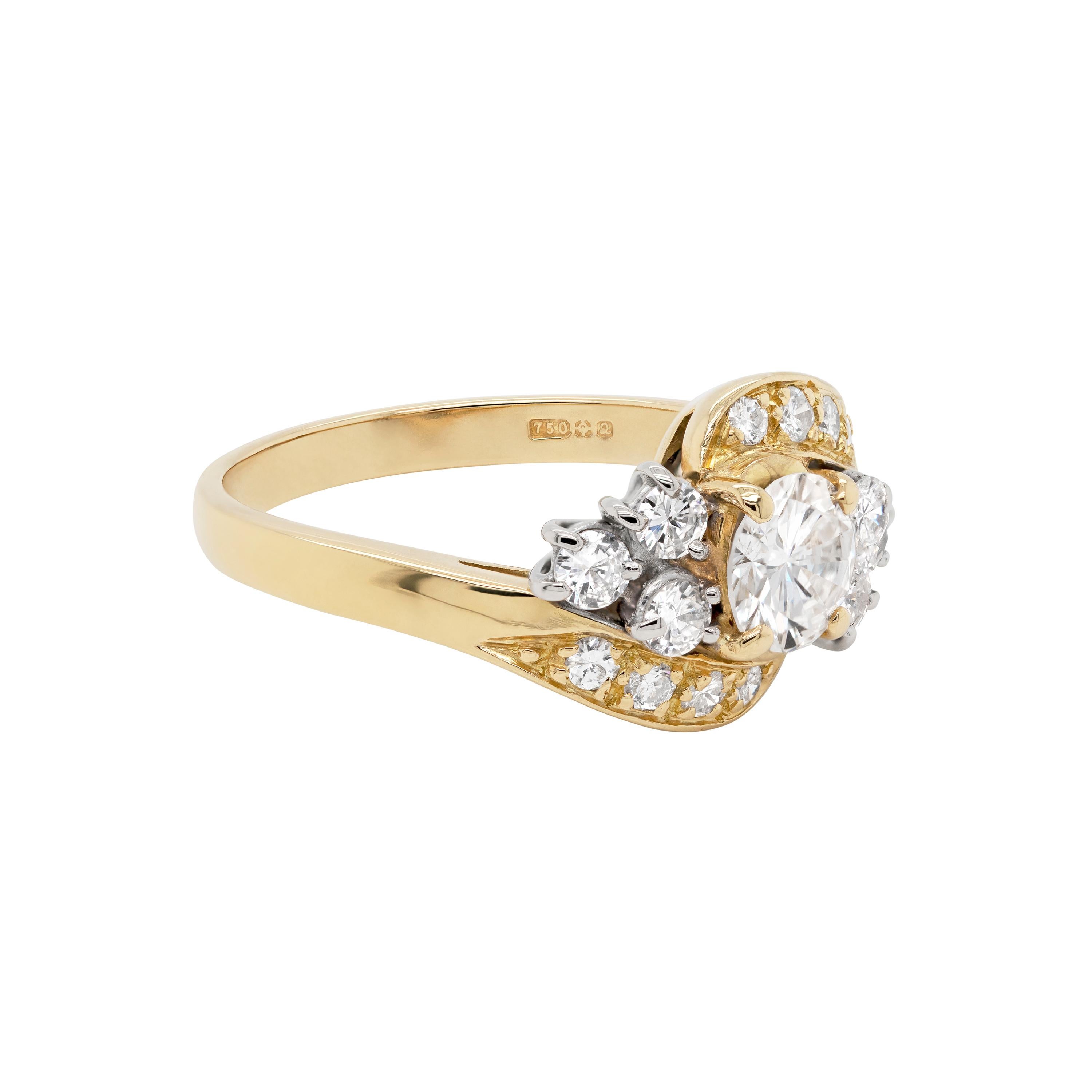 Dieser wunderschöne Twist-Dress-Ring ist mit einem runden Brillanten von 0,73 Karat besetzt, der in einer offenen Fassung mit vier Klauen sitzt. Der Solitär in der Mitte wird von drei runden Diamanten im Brillantschliff auf beiden Seiten geschmückt,