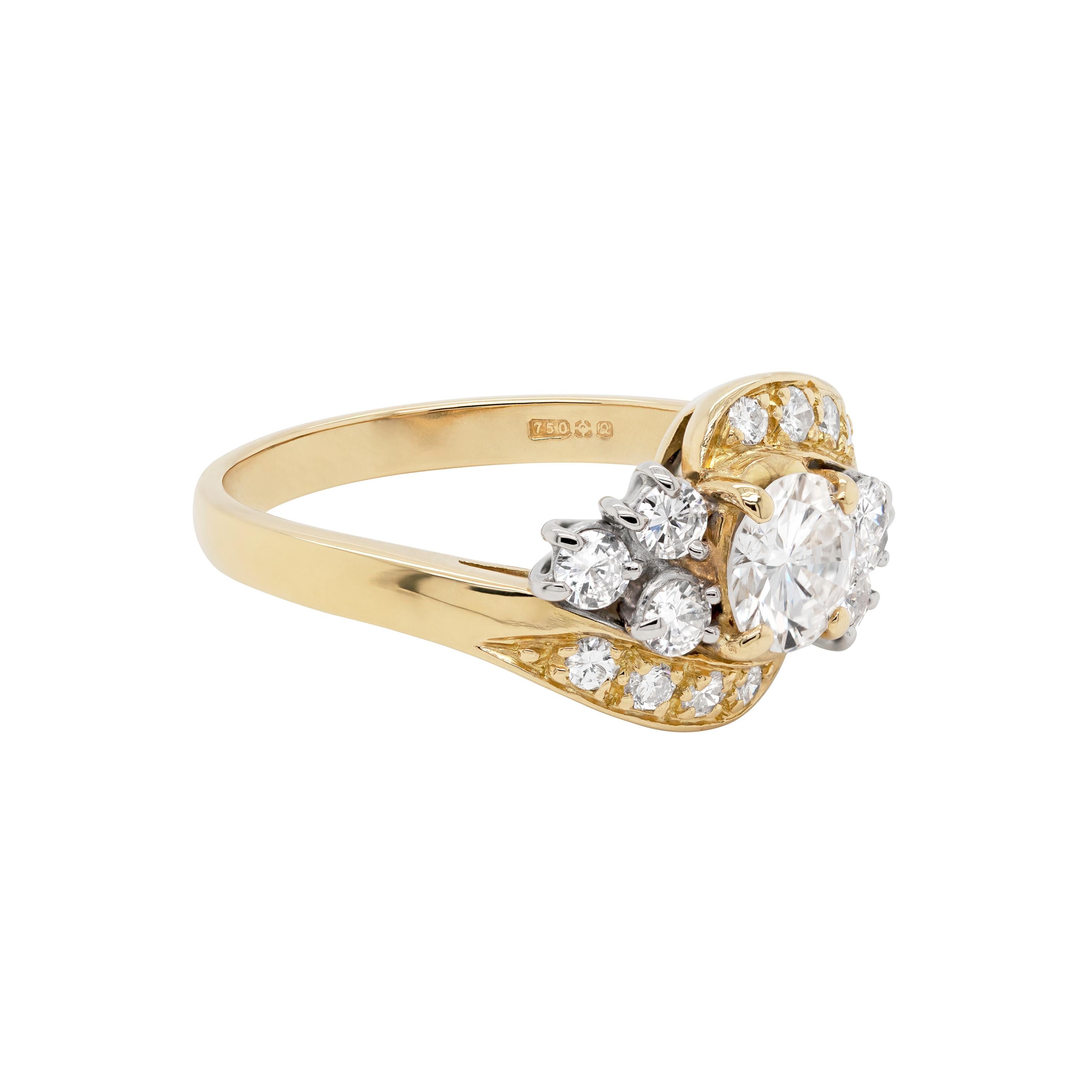 This beautiful twist dress ring features a 0.73ct central round brilliant cut diamond, mounted in a four claw, open back setting. The central solitaire is embellished by three round brilliant cut diamonds on either side, also mounted in four claw,