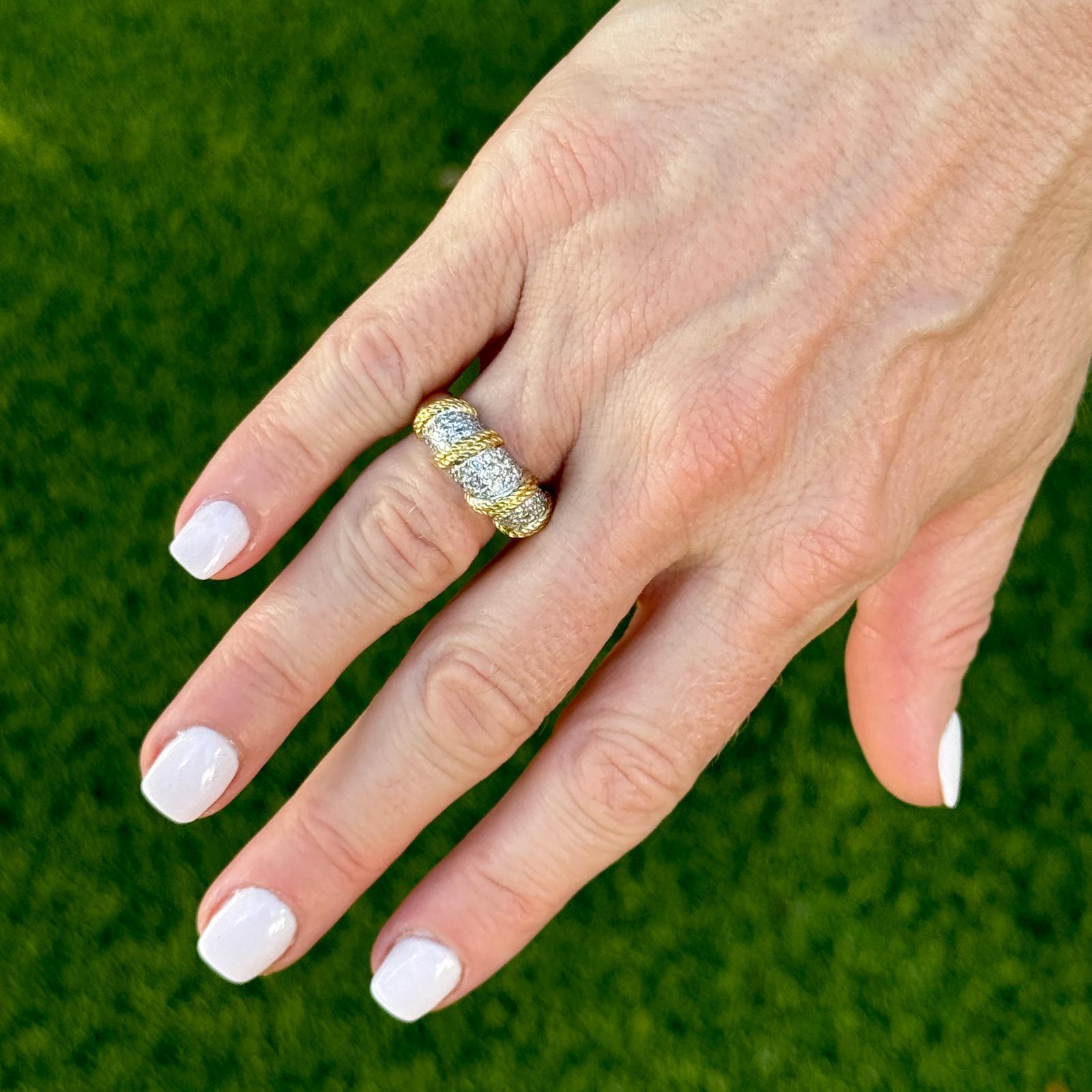 The Diamond Dome Ring with Rope Design is a striking piece that combines elegance and craftsmanship. Featuring a dome-shaped setting encrusted with 59 sparkling round brilliant cut diamonds, this ring is crafted from 18 karat yellow and white gold,
