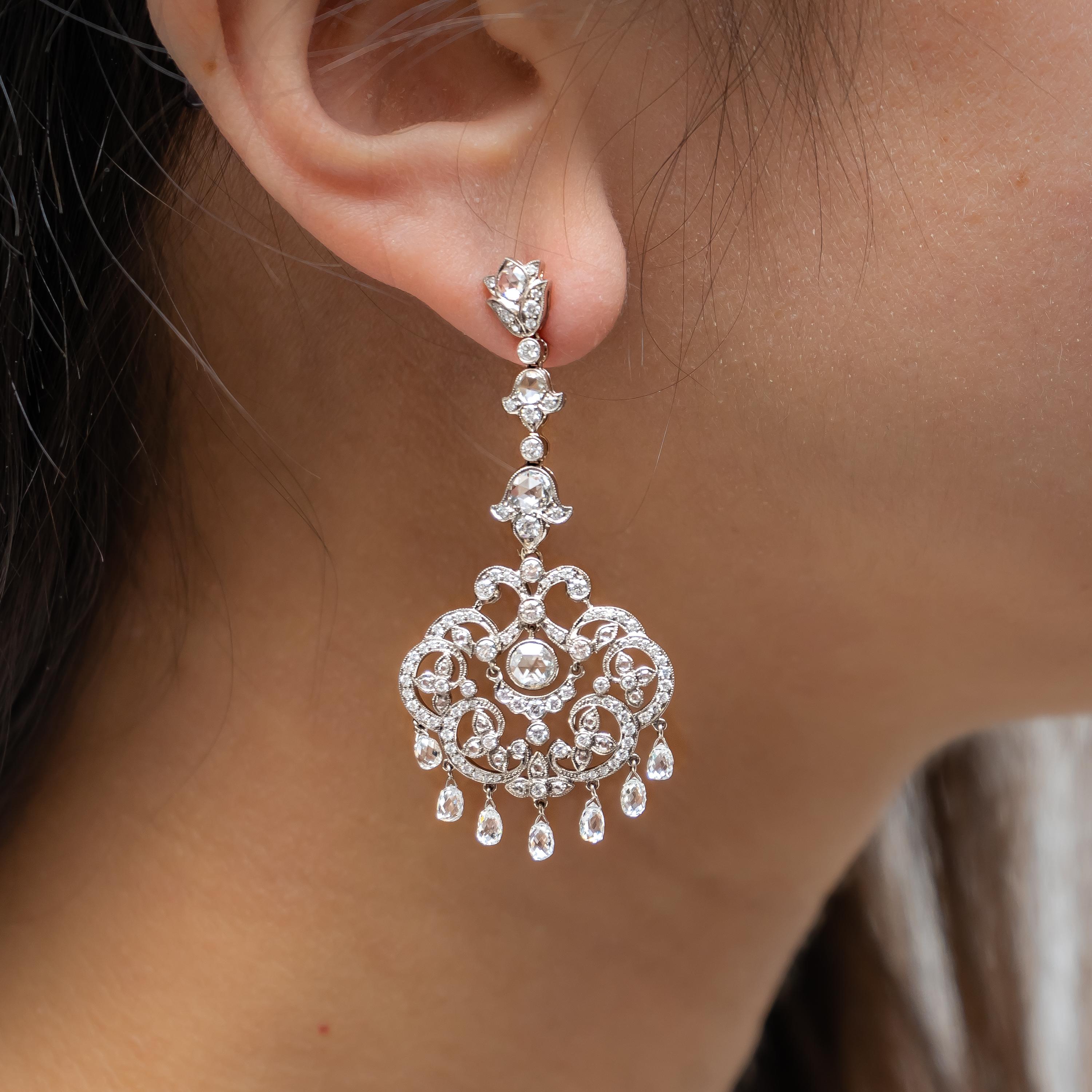 A pair of diamond drop earrings, with an openwork scrolled frame, with trefoil flowers, set with round brilliant-cut and rose-cut diamonds, each suspending seven briolette-cut diamonds, mounted in 18ct white gold, with a total diamond weight of