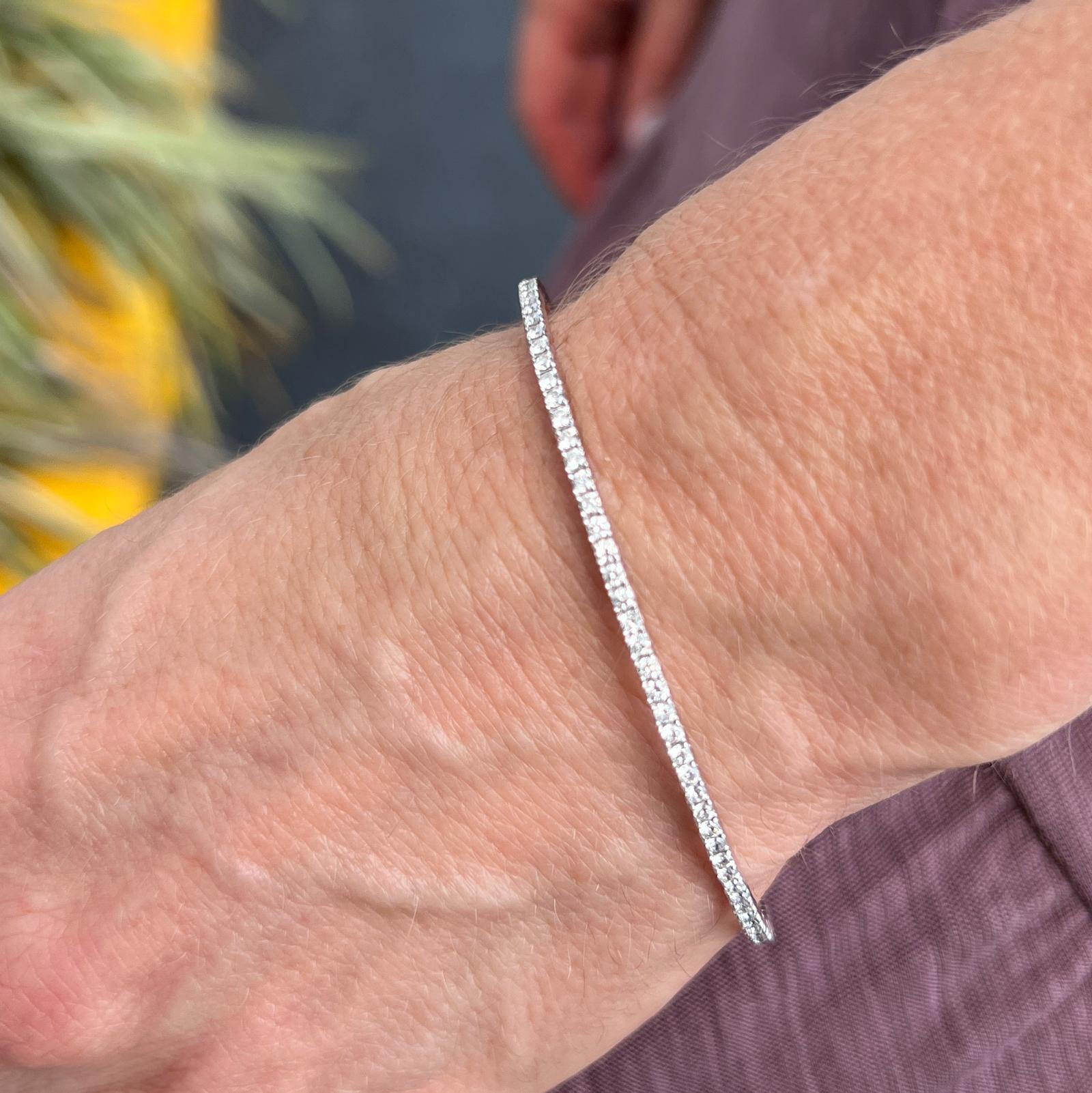 Modern stackable diamond bangle crafted in 18 karat white gold. The flexible bangle features 90 round brilliant cut diamonds weighing 1.62 carat total weight and graded F-G color and SI1 clarity. The bracelet measures 2mm in width and fits up to a 7