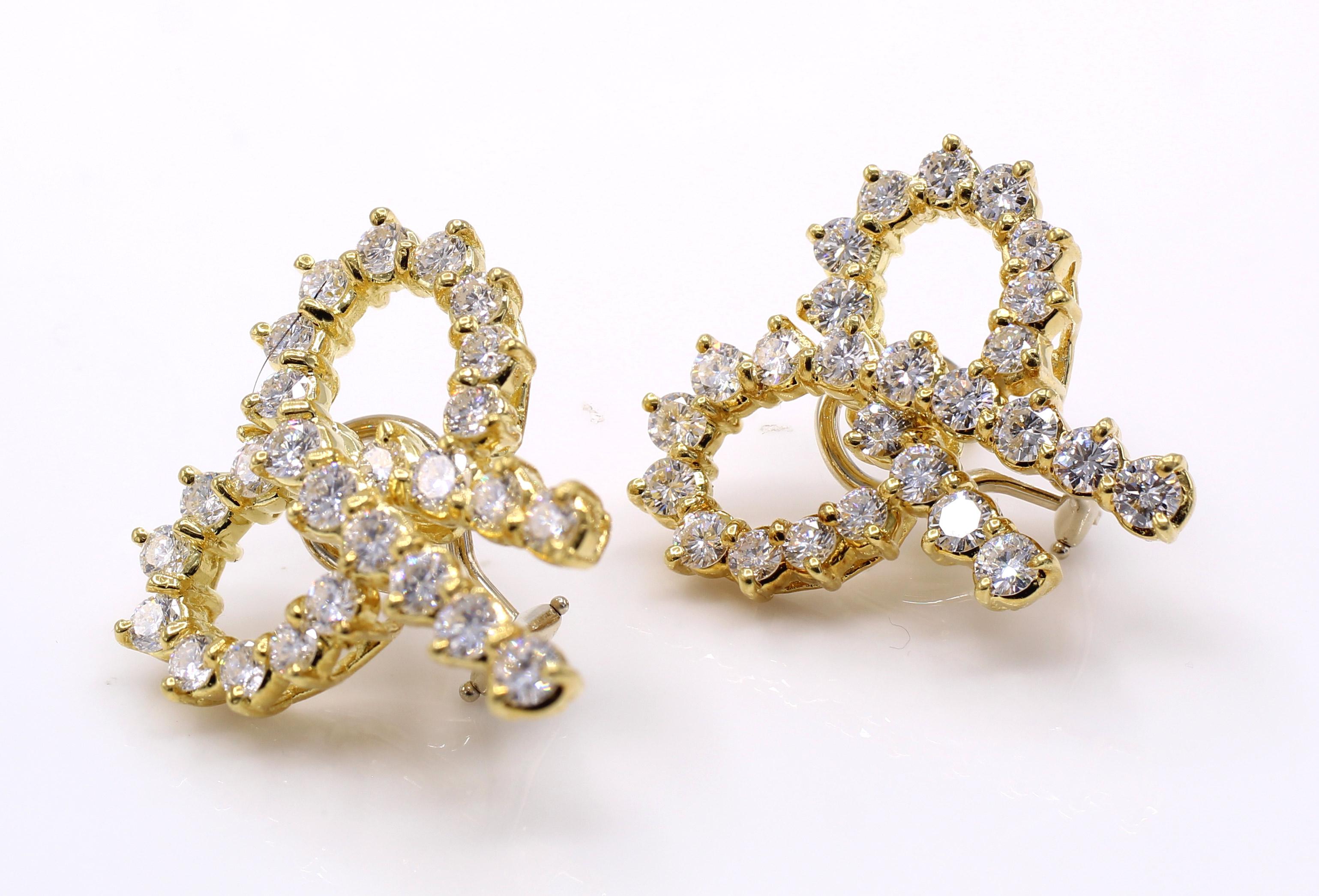 Beautifully designed as a pair of bows these wonderful yellow gold earrings are set with 52 bright white and sparkly round brilliant cut diamonds, with an approximate total diamond weight of 5.5 carats. Secured by a post and omega clip back. 
