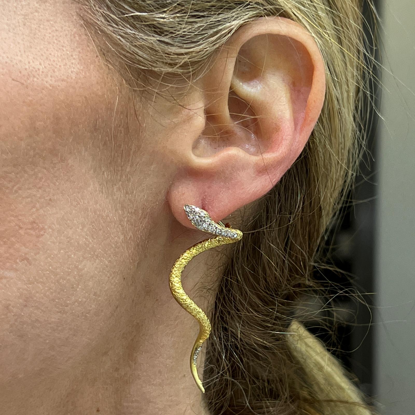 Fabulous diamond snake earrings handcrafted in 18 karat yellow gold. The earrings feature 38 round brilliant cut diamonds weighing approximately .40 CTW and graded G-H color and SI clarity. The earrings measure 2.00 inches in length and feature
