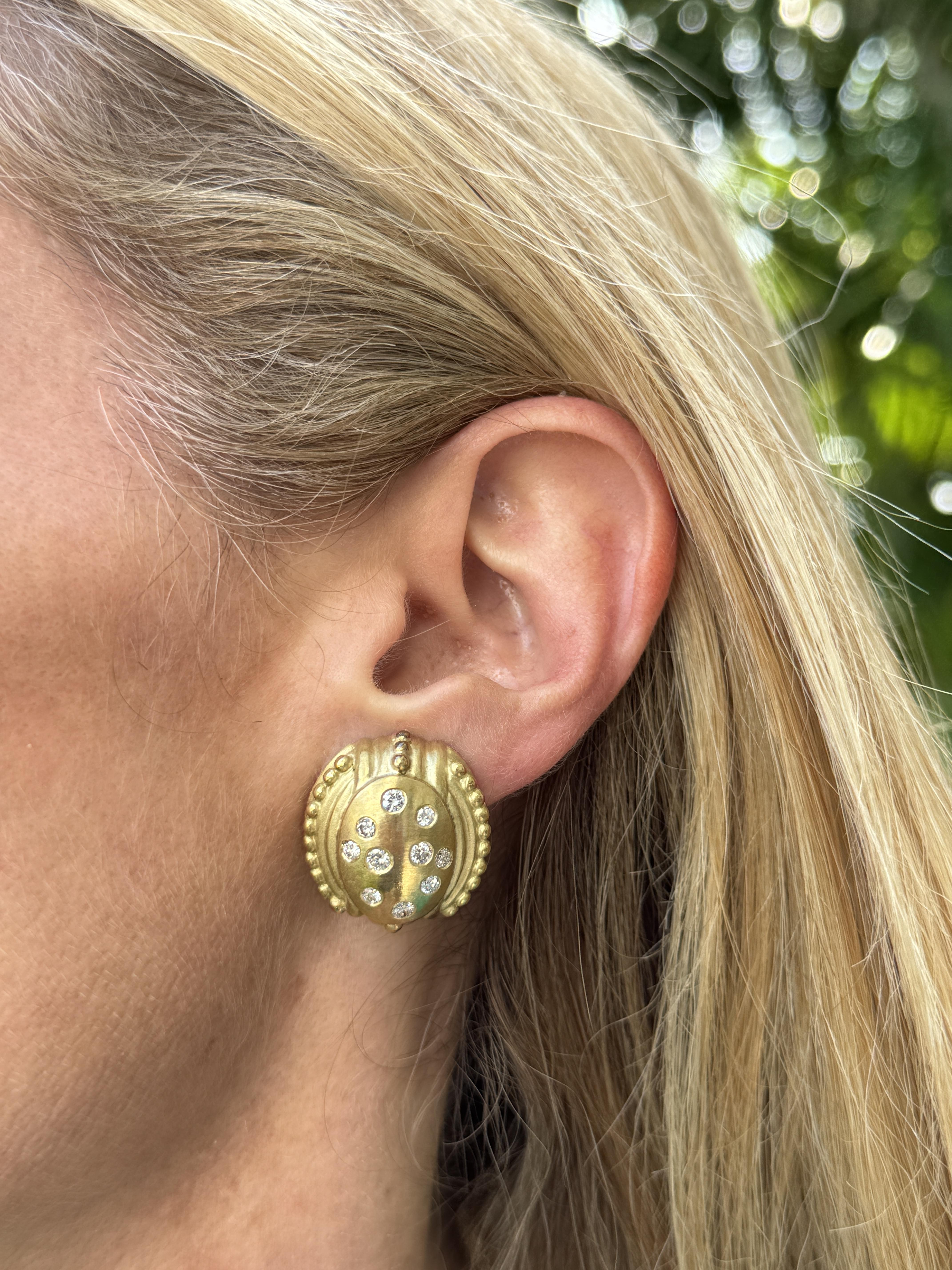 Etruscan style diamond earrings crafted in 18 karat yellow gold. The gold surface of the earrings has a satin finish, which gives it a soft, matte appearance. This finish adds a touch of elegance and sophistication to the earrings  while also