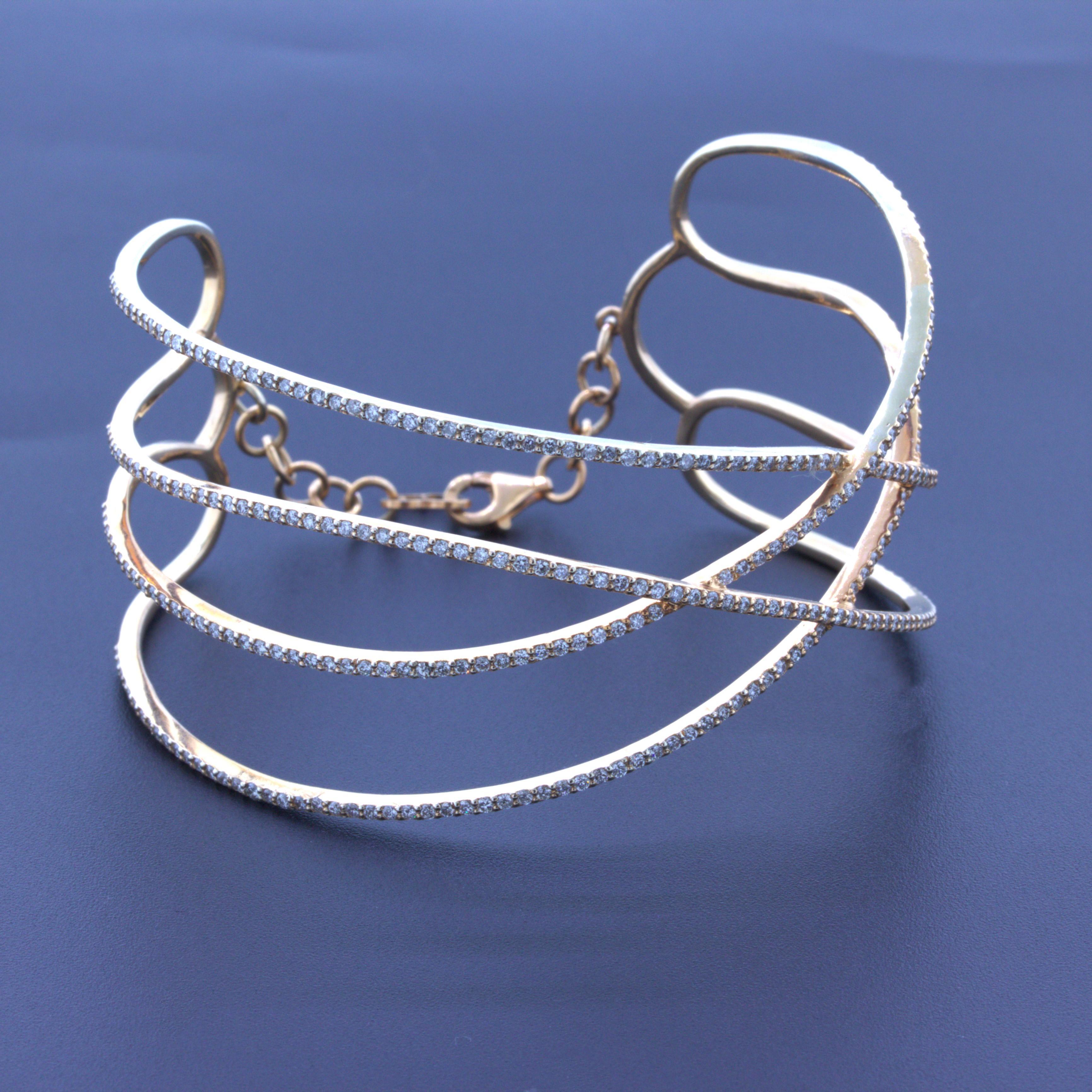 Un bracelet bangle amusant et élégant avec 3,96 carats de diamants ronds de taille brillant. Ils sont sertis sur des rangs d'or jaune et rose 18 carats qui se croisent et s'entrecroisent pour un design élégant. En outre, le bracelet présente un