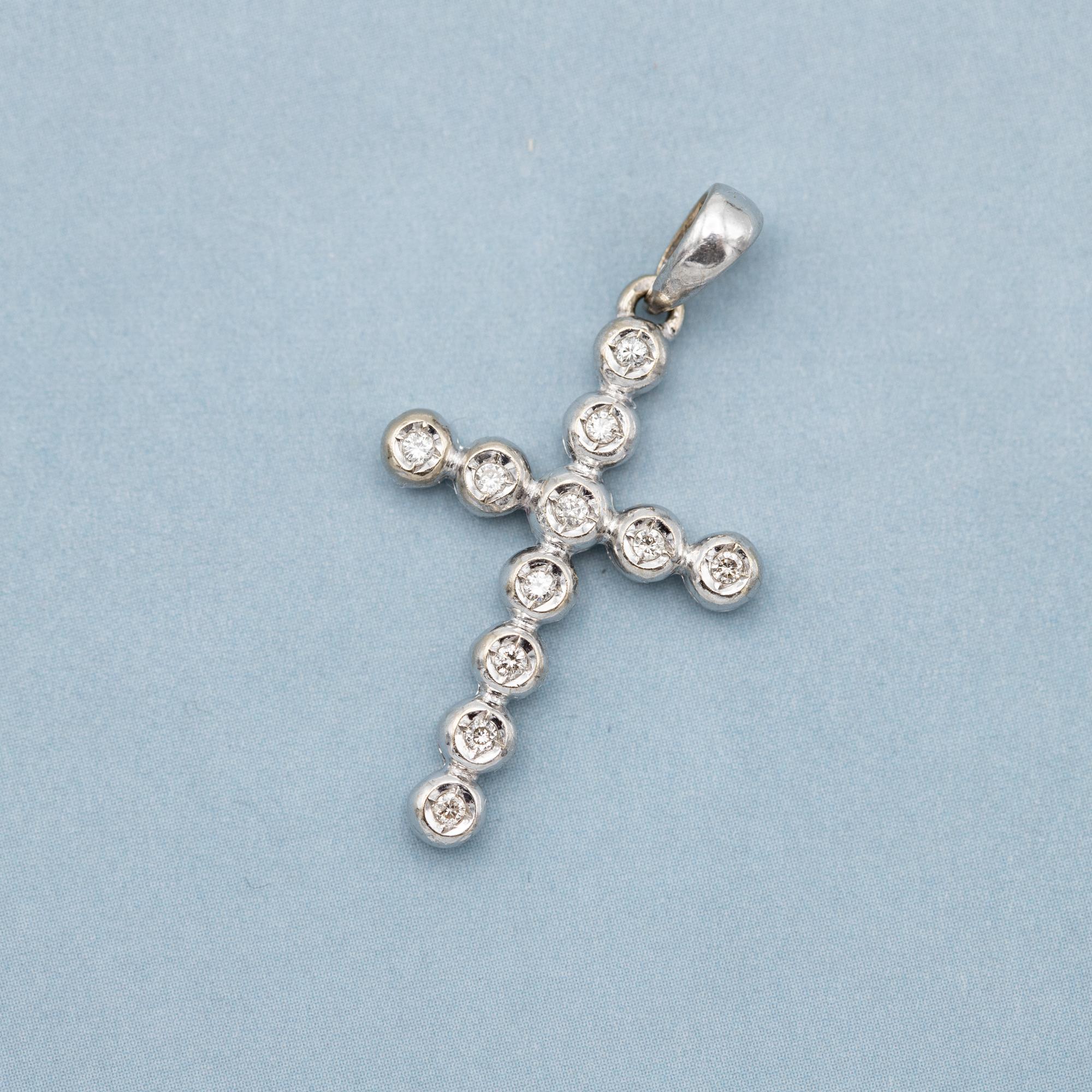 Nous vendons ce joli pendentif en forme de croix en or blanc 18 K. Cette magnifique petite breloque détaillée est recouverte de onze petits diamants de taille brillant qui totalisent 0,1ct. Ces diamants étincelants sont placés en forme de croix.

Il