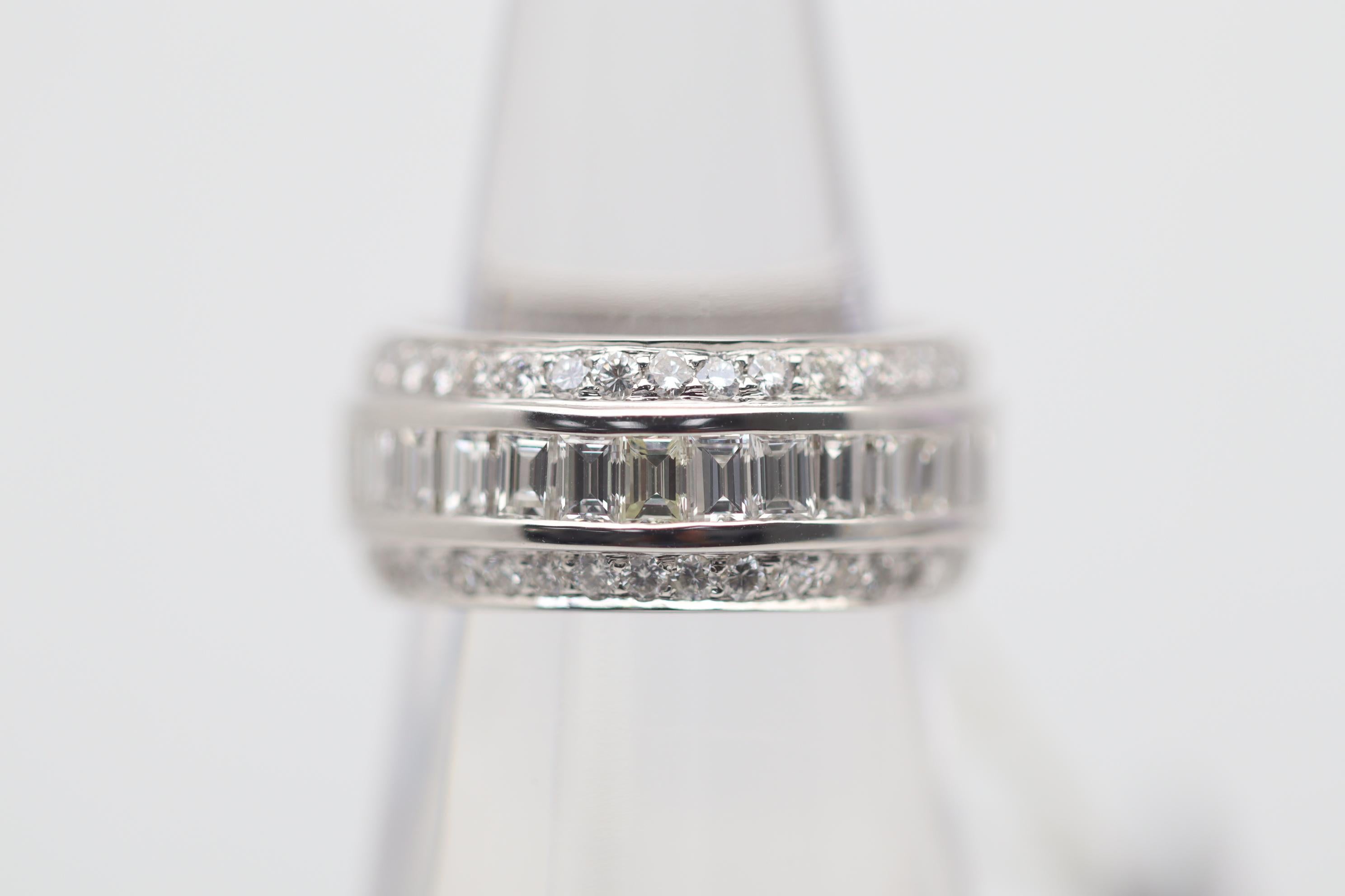 A unique take on the classic diamond eternity ring! This piece features a single row of baguette-cut diamonds which are channel-set in the middle along with two outer rows of round brilliant-cut diamonds. The total diamond weight is 5.09 carats, and