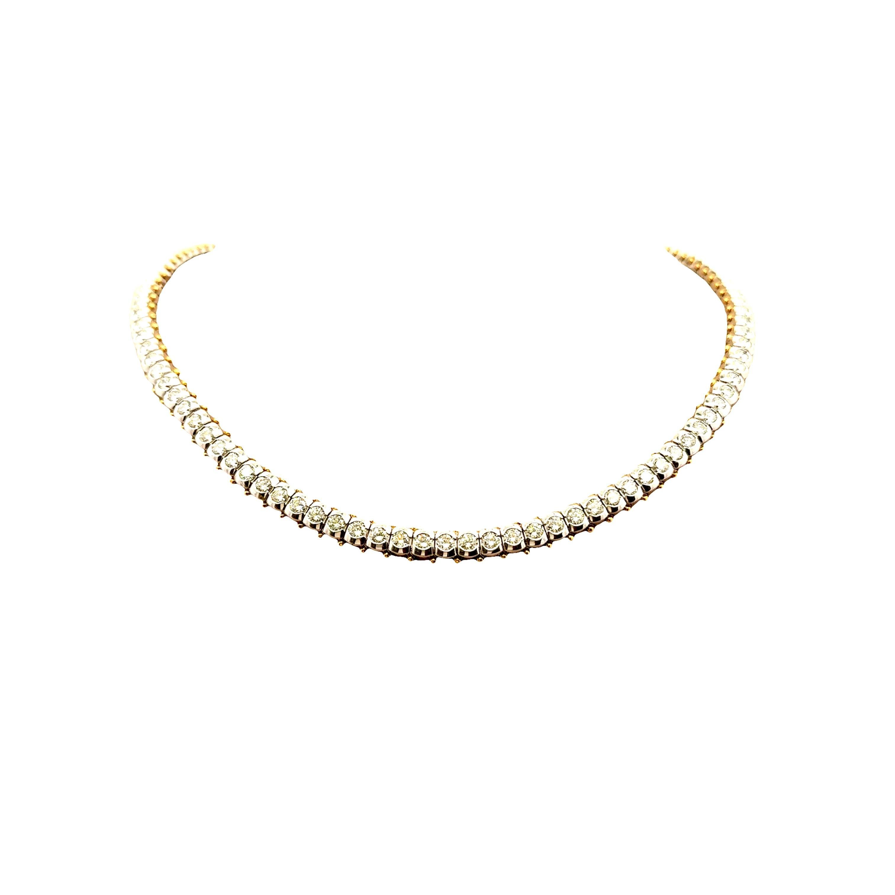 Un refinado collar tenis con diamantes blancos talla redonda, que suman 15,88 quilates. Cada diamante está meticulosamente engastado, creando una línea continua de brillo. El collar está elaborado en oro blanco de 18 quilates con detalles en oro