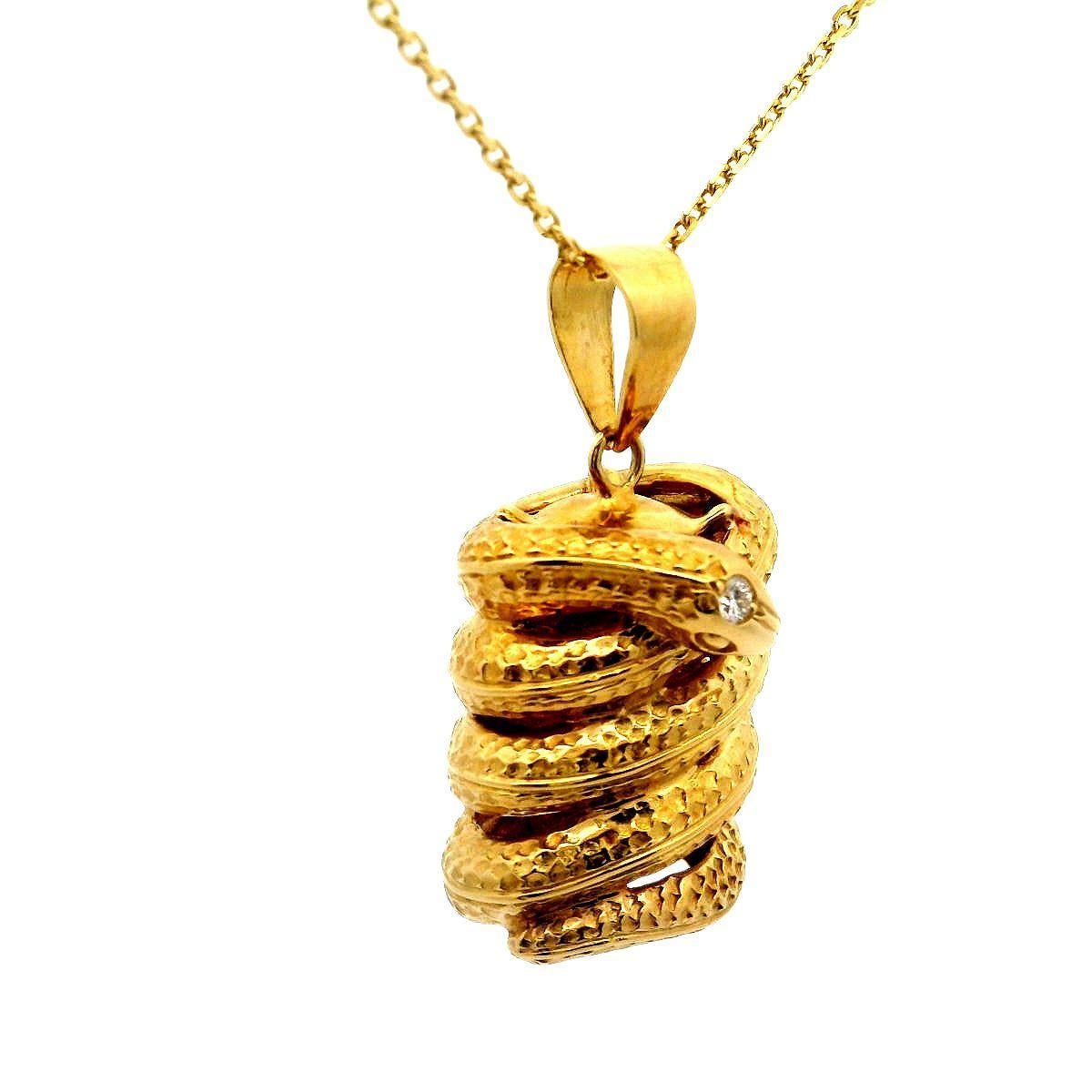 Ce pendentif remarquable est orné d'un serpent d'or méticuleusement travaillé. Le serpent est enroulé de manière complexe, présentant des écailles détaillées et une forme réaliste. Sa tête est ornée d'un diamant blanc rond, qui lui confère un éclat