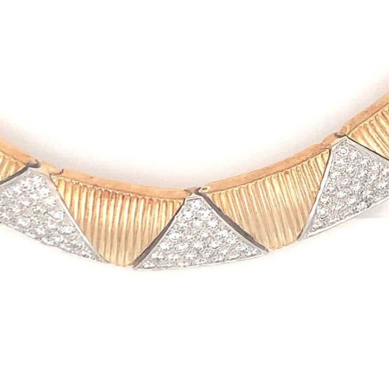 One diamond 18K yellow gold necklace designed as a collar of ribbed triangular links. Enhanced with pave set portions featuring 140 round brilliant cut diamonds totaling 5 ct. Circa 1970s.

Abstract, amazing, alluring.

Additional