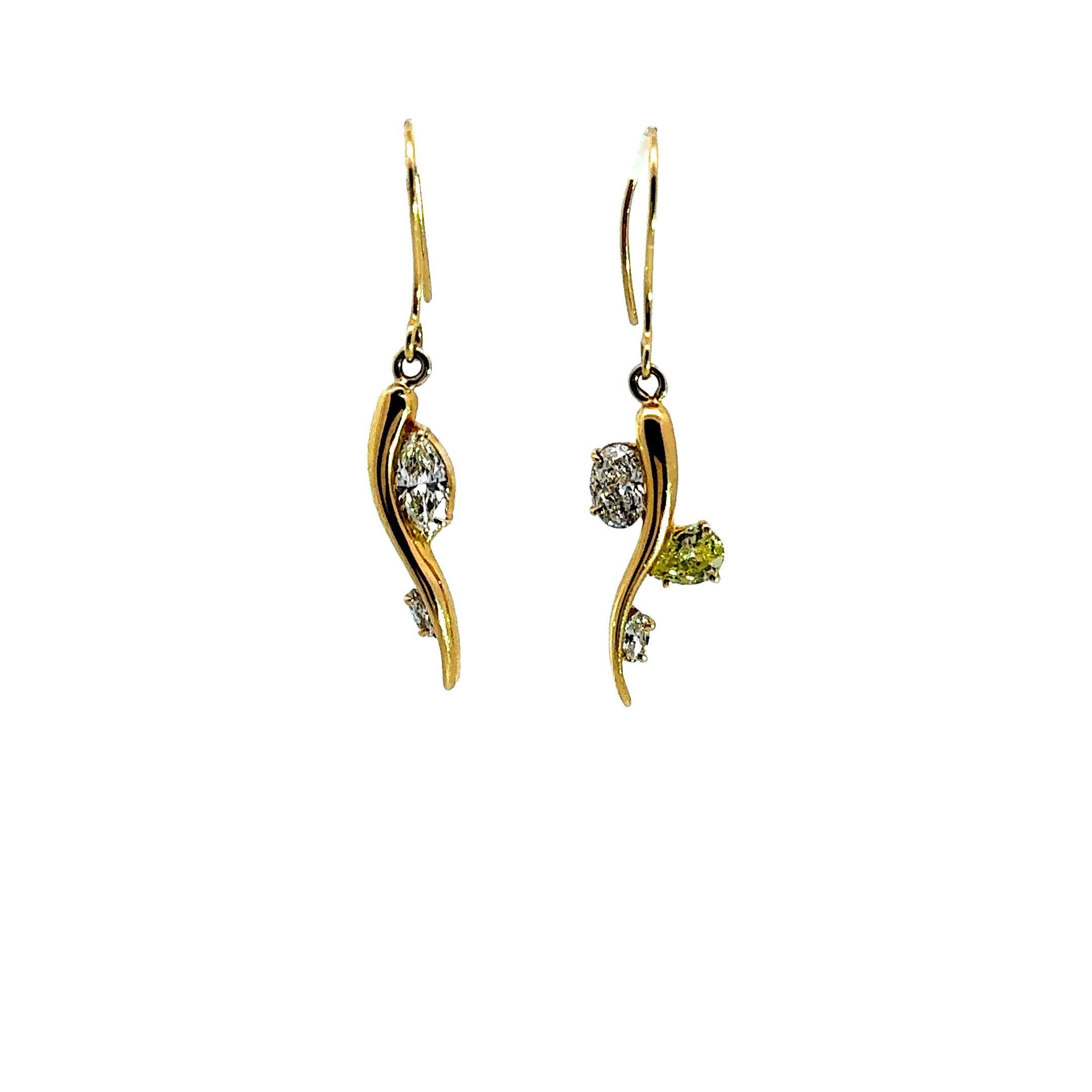 Un paio di orecchini a goccia di grande effetto, con un design fluido e ondulato in oro giallo 18 carati. Ogni orecchino è impreziosito da grandi diamanti, ovali, marquise e a pera, per un peso totale di 1,22 carati. Le curve eleganti dell'oro