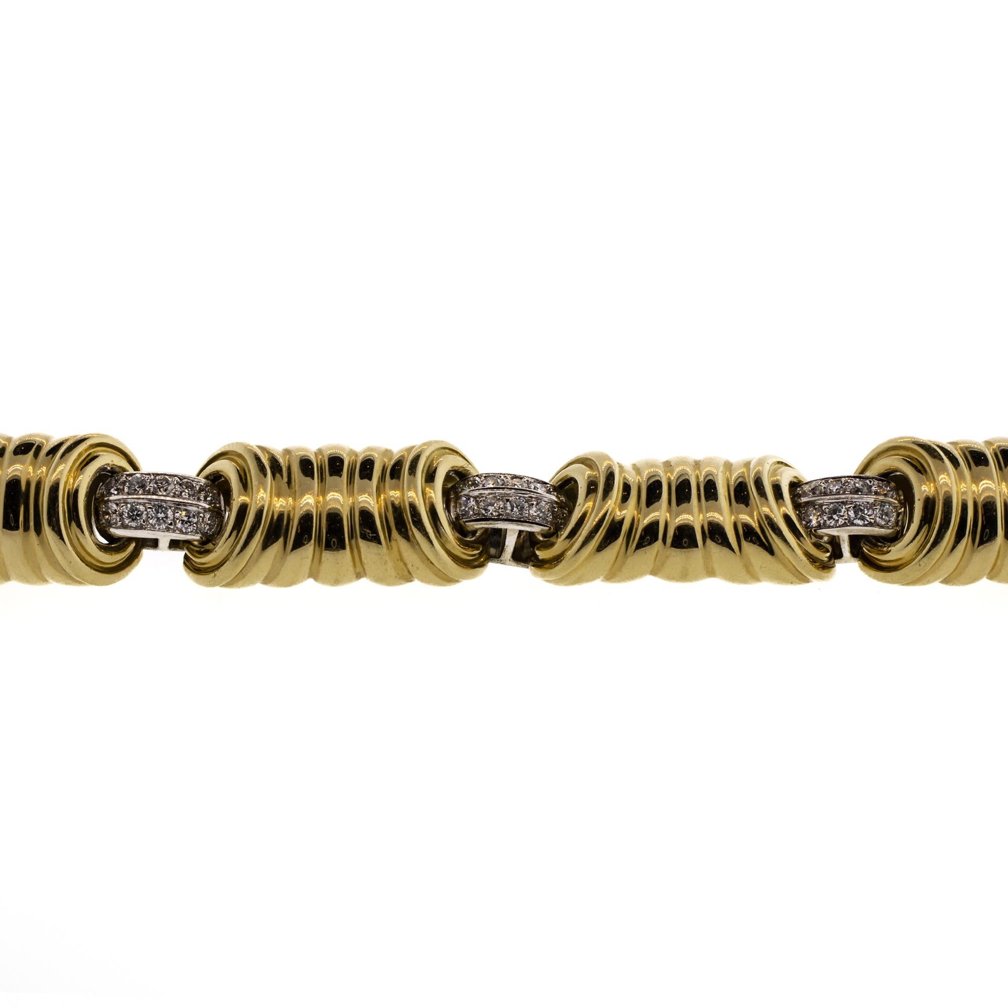 This is a stunning custom designed weighty addition to anyone's collection. Made from solid 18k gold, these seven slightly concave corrugated yellow gold links are separated by contrasting diamond studded white gold links. There are approximately