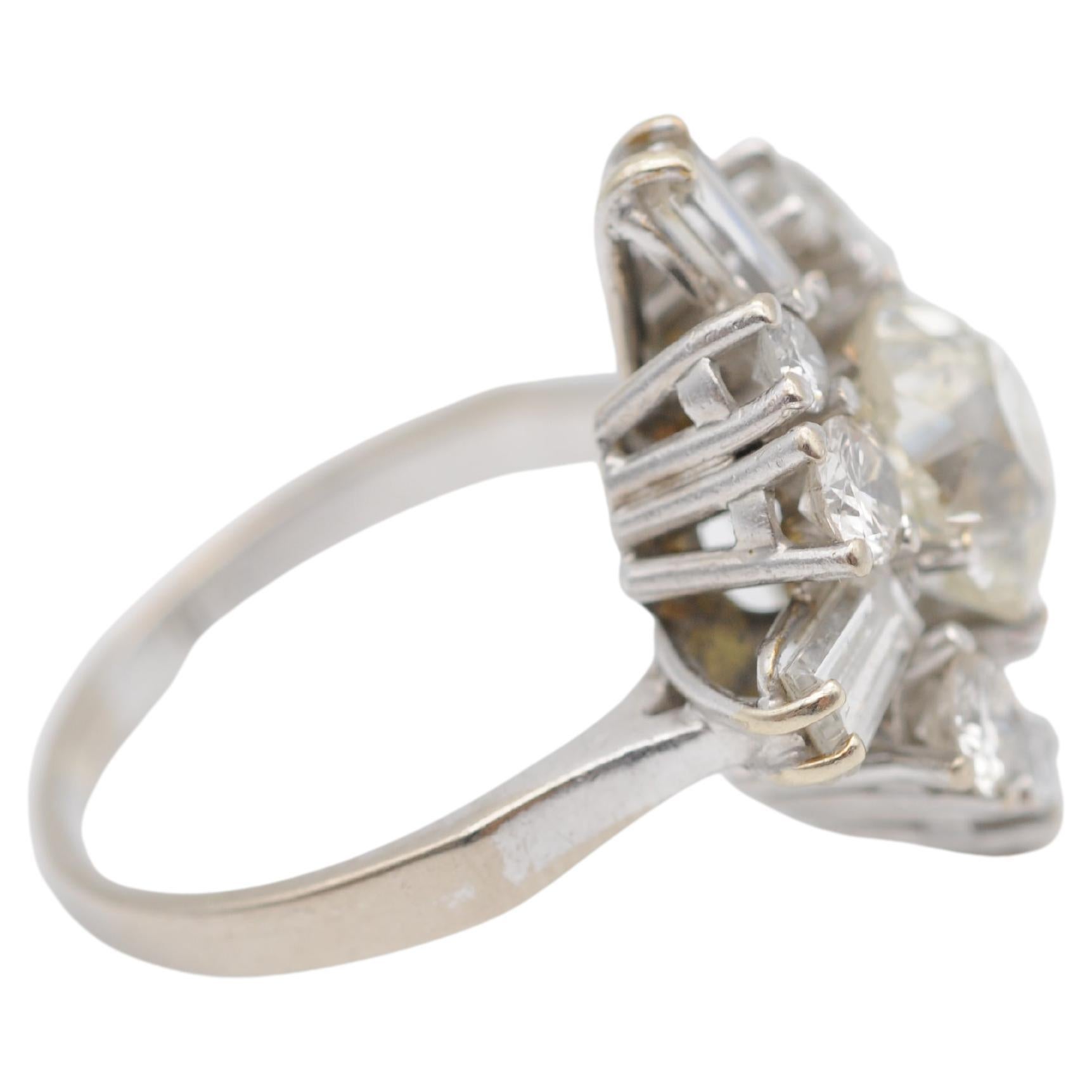 Behold the epitome of luxury and elegance - an exquisite ring crafted from 18K white gold, featuring a stunning old European cut diamond of approximately 2 carats. The centerpiece is further embellished by a mesmerizing display of diamonds - 8