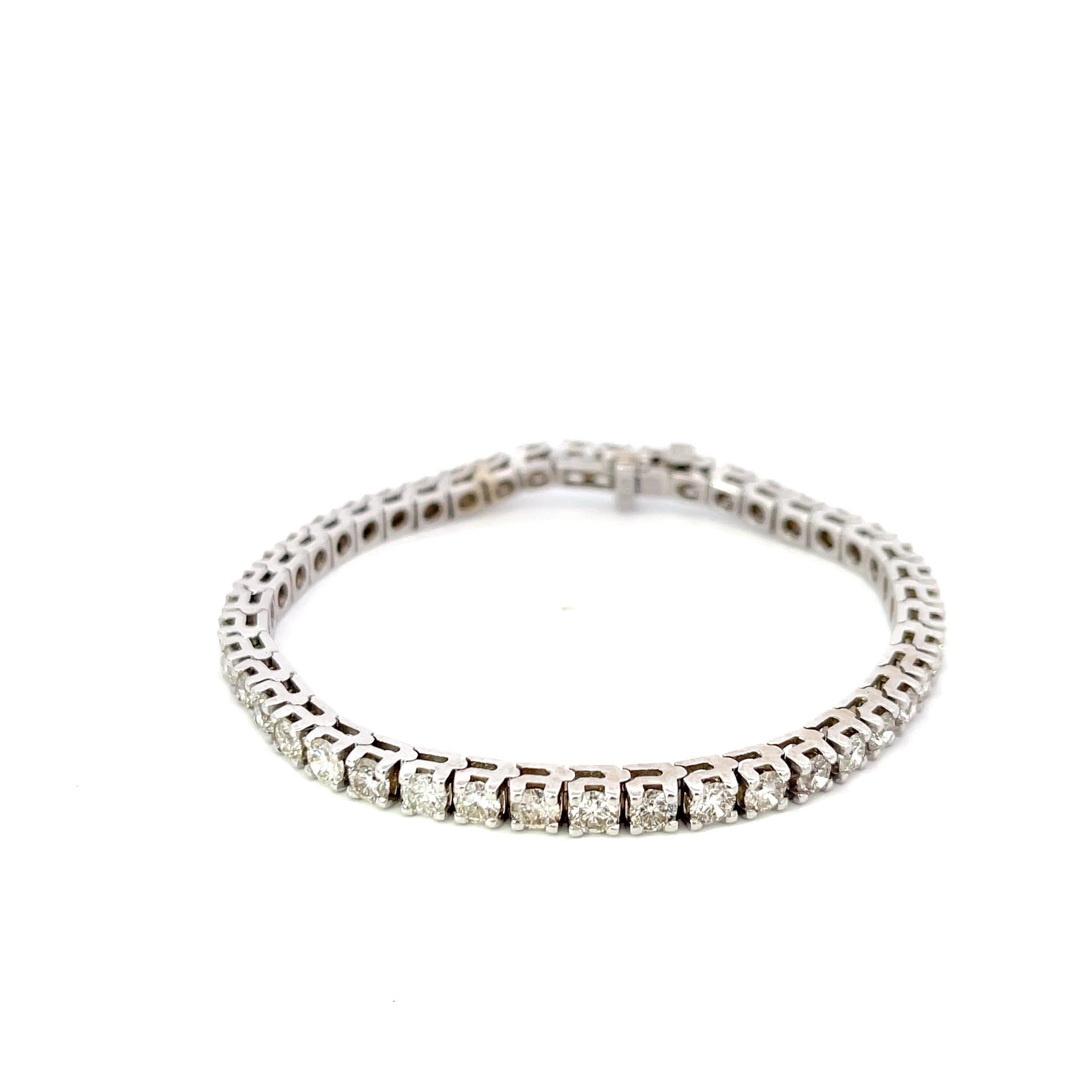 Diamond Tennis Bracelet in 14K White Gold. The bracelet features 44 brilliant round diamonds with 6.60ctw, H-I color, SI2-I1 clarity. The bracelet is 7 inches long, 3.75mm wide, and weighs 17.66 grams.