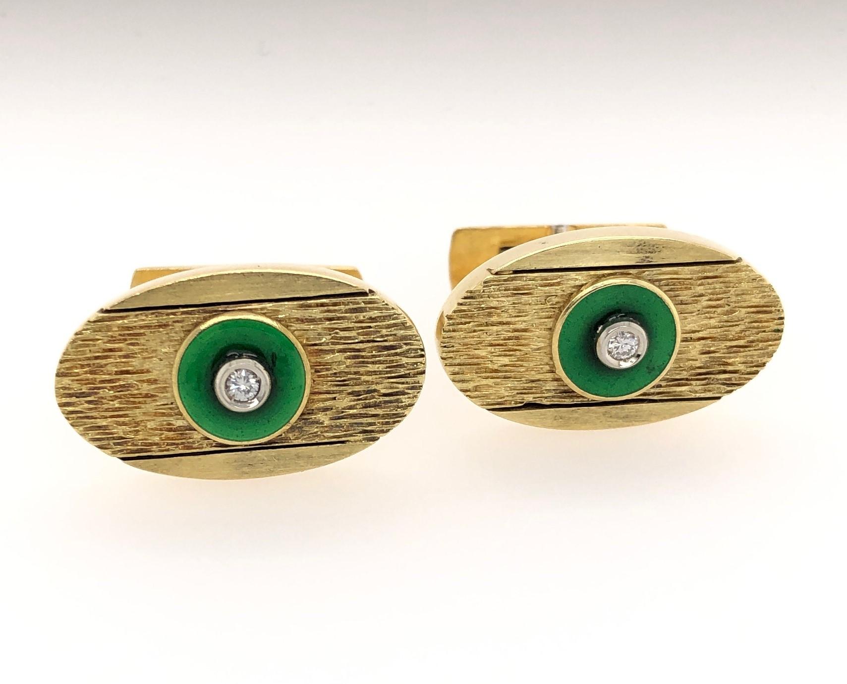 For the dapper dresser, eighteen carat 18K yellow gold oval cuff links with green enamel applique showcasing a bezel set round cut diamond.
Measuring approximately 1 x 5/8 inch with textured satin gold detailing to handsomely offset the rich green