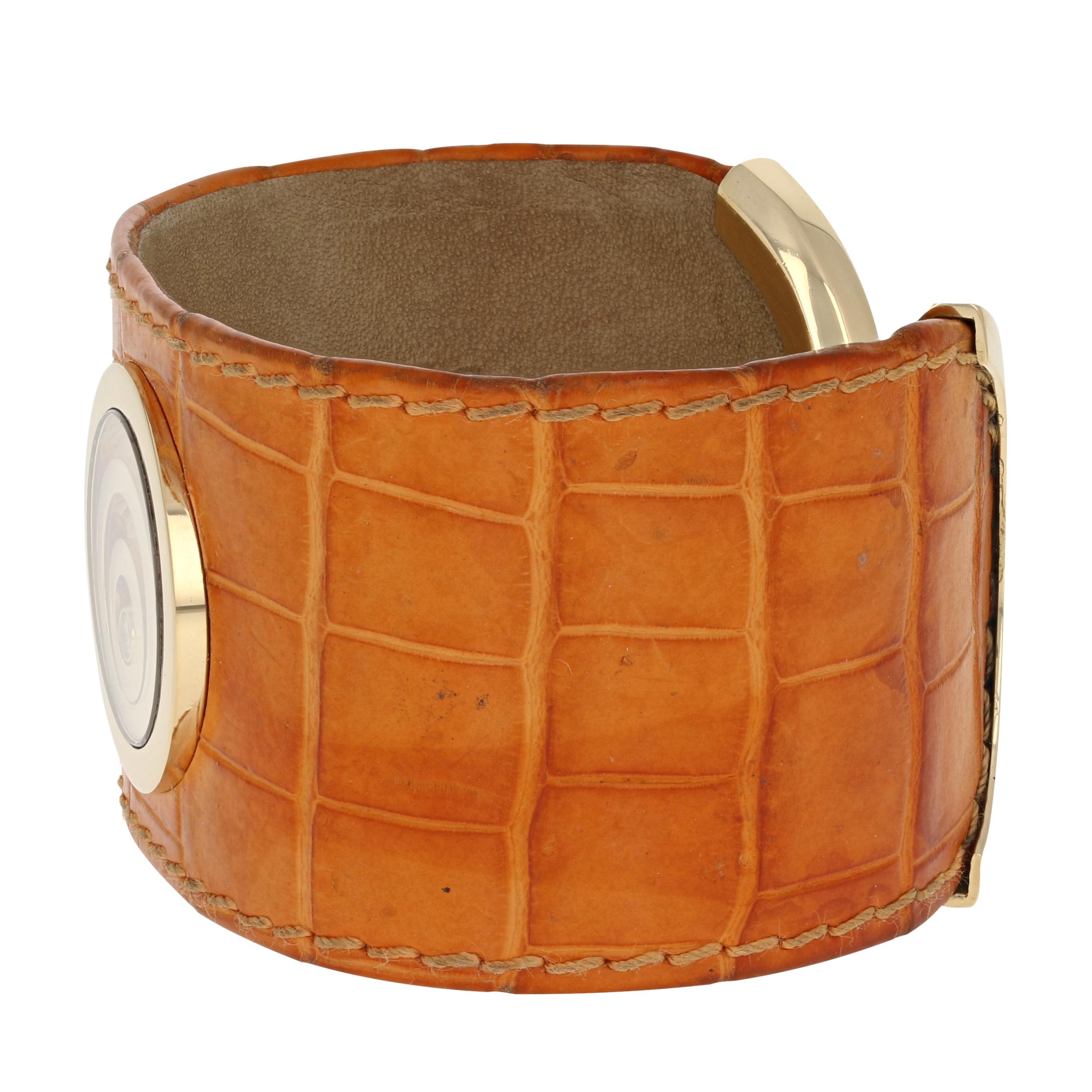 Celebrate the special woman in your life with this stylish piece by Chopard! Part of the Happy Spirit Collection, this light brown genuine alligator leather cuff bracelet is adorned with concentric 18k yellow gold circles and a white diamond accent