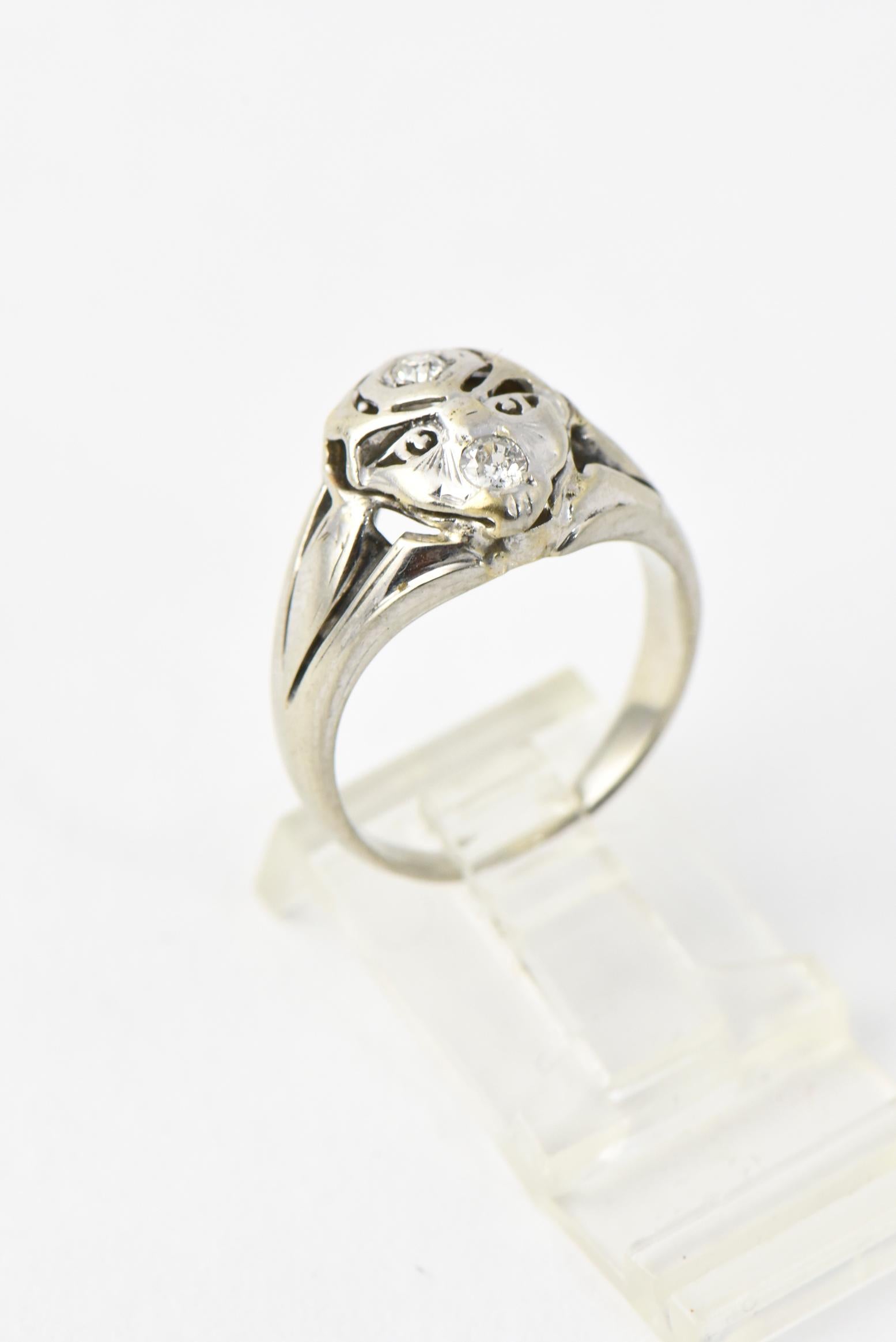 Mid 20th century 14K white gold ring featuring an abstract face with a diamond set on the forehead and mouth. Diamonds total approximately .14 carats. US size 7; can be sized. Age wear.