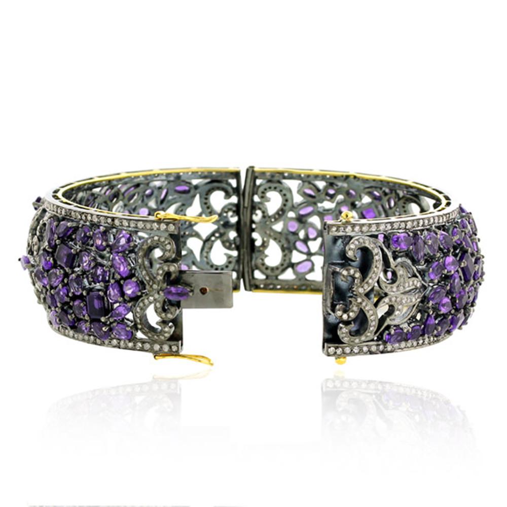 This Diamond Amethyst Designer Mosaic Bangle Bracelet in Silver and 18K Gold is pretty and wraps around the wrist very nicely. This bangle opens on side and has box clasp.

18kt gold:6.2gms
Diamond:5.1cts
Silver:44.15gms
Amethyst:27.02cts
