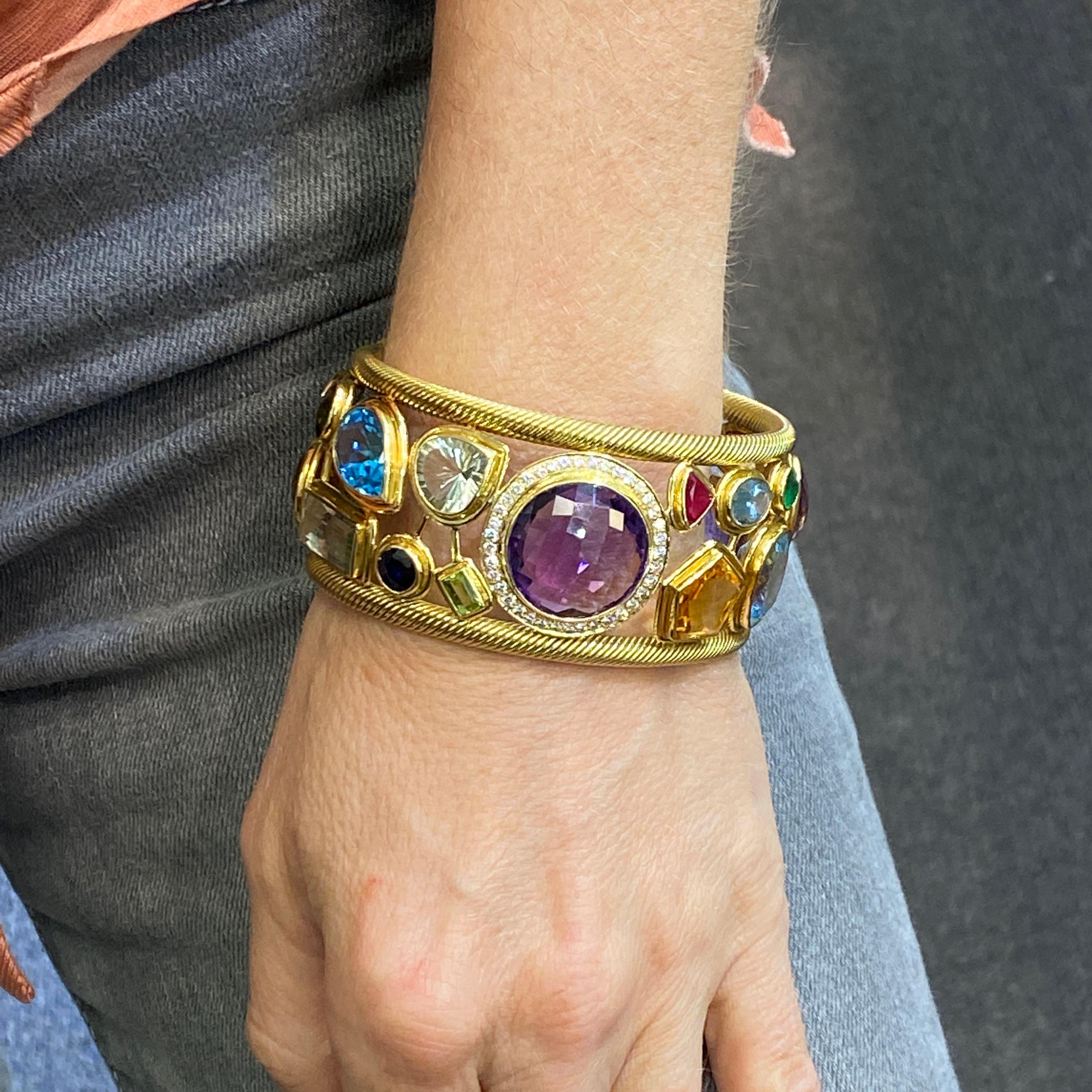 Beautifully crafted solid 18 karat yellow gold open cuff bracelet set with diamonds and colorful gemstones. The bracelet features 38 round brilliant cut diamonds weighing approximately 1.15 carat total weight and graded G-H color and VS clarity. The