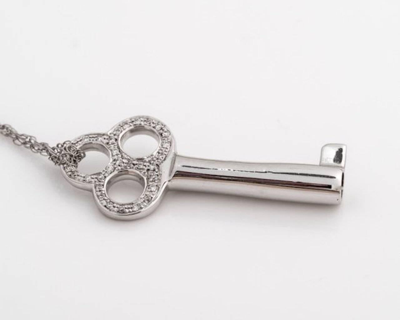 1980s Key Pendant - 14k White Gold, Diamonds

This skeleton key design pendant features open circles at the top with a hollow cylinder shaft. 
The open circles are encrusted with bezel set Diamonds.
This pendant is accompanied with the chain as seen
