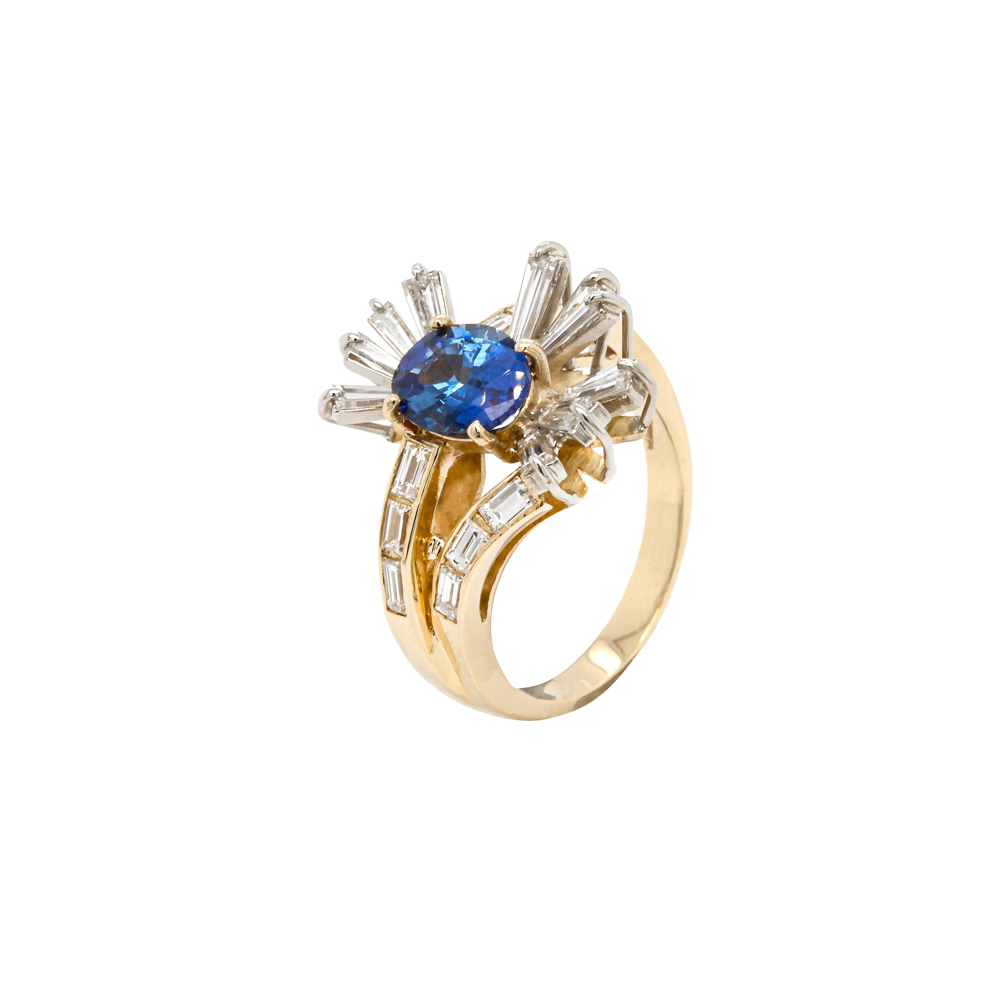 This striking sapphire and diamond spray cluster dress ring screams mid-century glamour.

A gorgeous oval cut royal blue sapphire weighing 1.77 carats is claw set in an asymmetrical spray of stunning tapered baguette cut diamonds. The ring's
