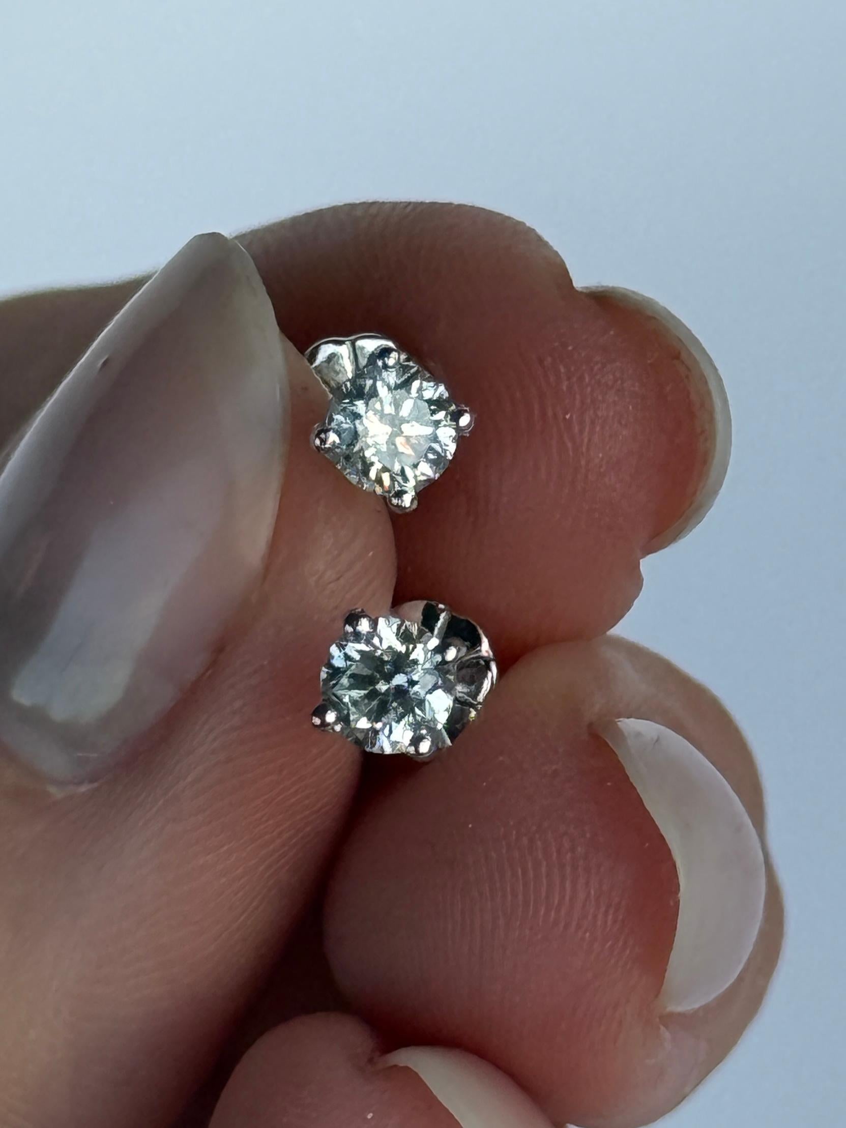 A pretty pair of shimmering diamond stud earrings. Each earring hosts a brilliant white diamond measuring 52pts in total. Modelled in 18 carat white gold. 

Stud Height From Ear: 3.5mm 
Diamond Diameter: 3.5mm

Weight: 1.1g