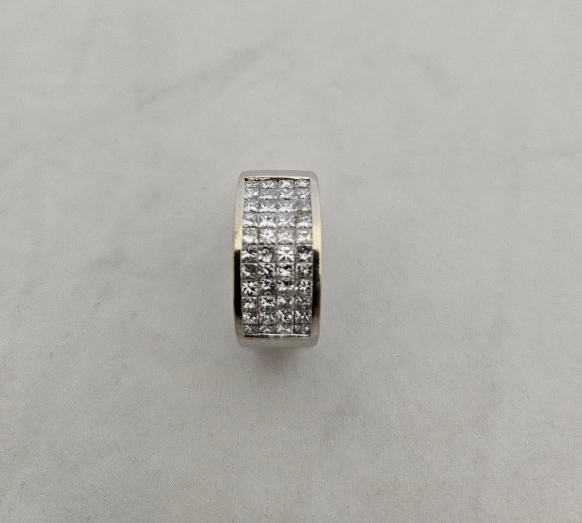 A beautiful bold band invisibly set with sparkling & shimmering square cut princess diamonds. All gems display a heavenly brilliant color. The ring size is six & three quarters It contains four rows with eleven diamonds in each row. The band is