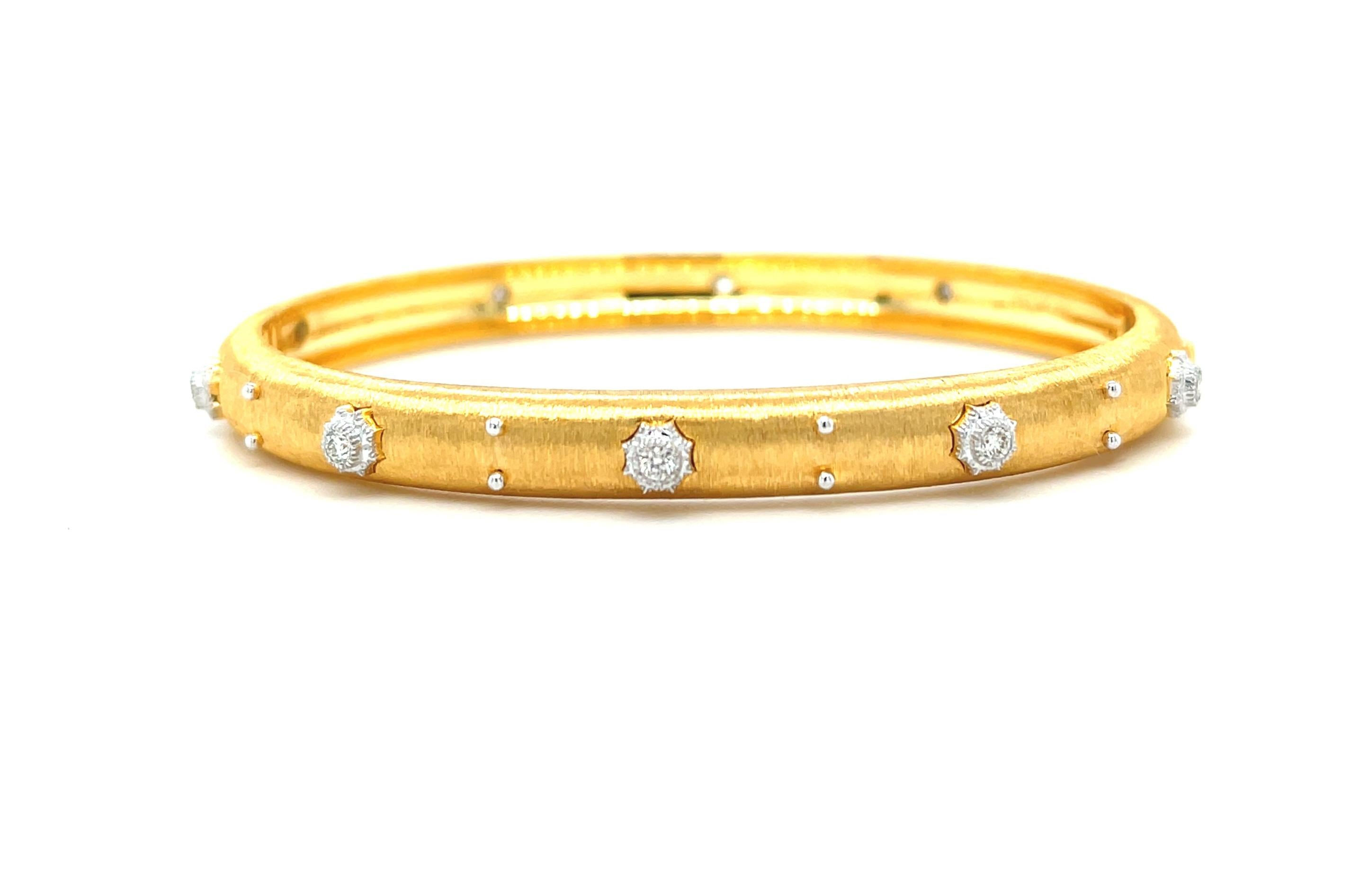 This elegant, 18k yellow gold bangle bracelet is really eye-catching! The bangle is finely textured with a beautiful satin finish, and is set with 10 sparkling white diamonds! Each diamond is set in its own 18k white gold, intricately detailed