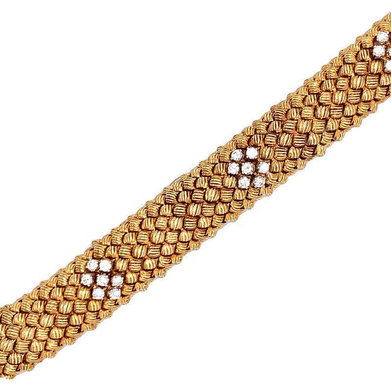 This exquisite and bold diamond bracelet from the 1960s is a substantial statement piece, meticulously crafted in luxurious 18K yellow gold. The bracelet features individual textured gold links that create a rich and dynamic pattern, enhancing the
