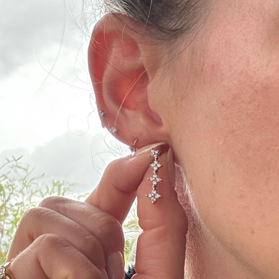 Questi orecchini sono realizzati in oro 9 carati con diamanti incastonati. Il totale dei diamanti di ogni orecchino è di 25 punti. Questi orecchini sono certificati. 

Diametro del grappolo: 4-6 mm 
Goccia dall'orecchio:  20mm

Peso: 2.1 g